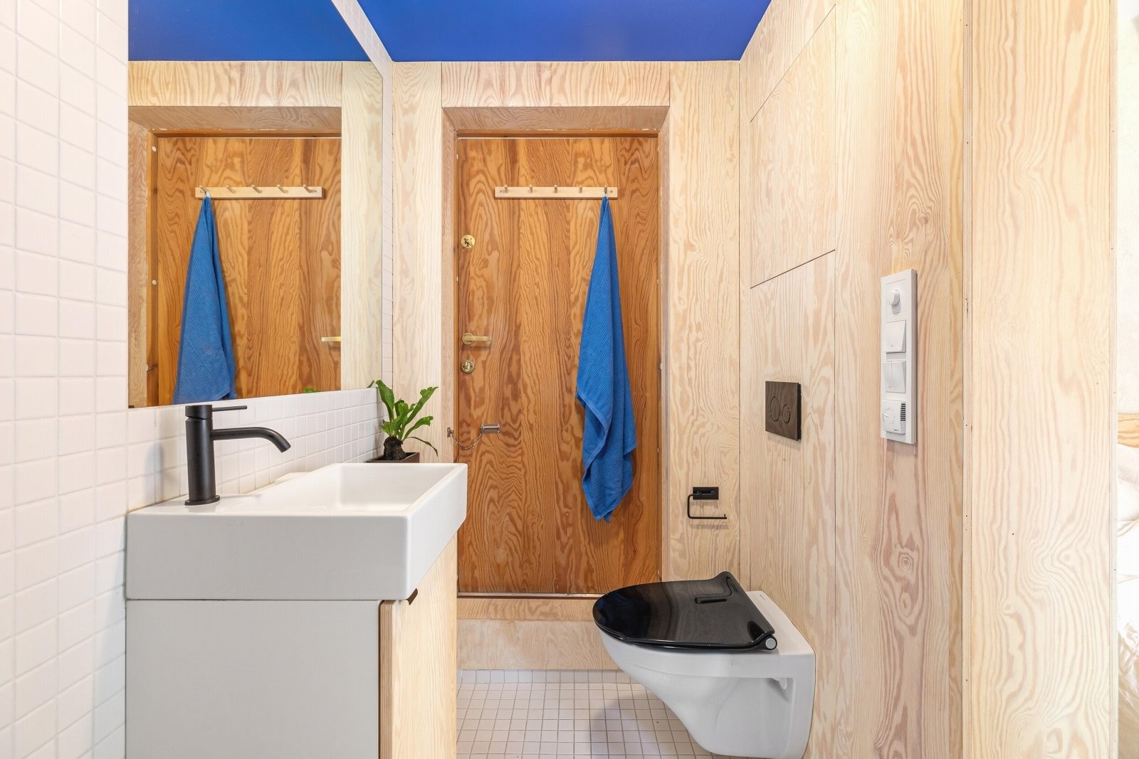 Rommet inneholder varmekabler, et servantskap med underskap, speil og lys, vegghengt toalett, plassbygde skap og et badekar med hånddusj. Galleribilde