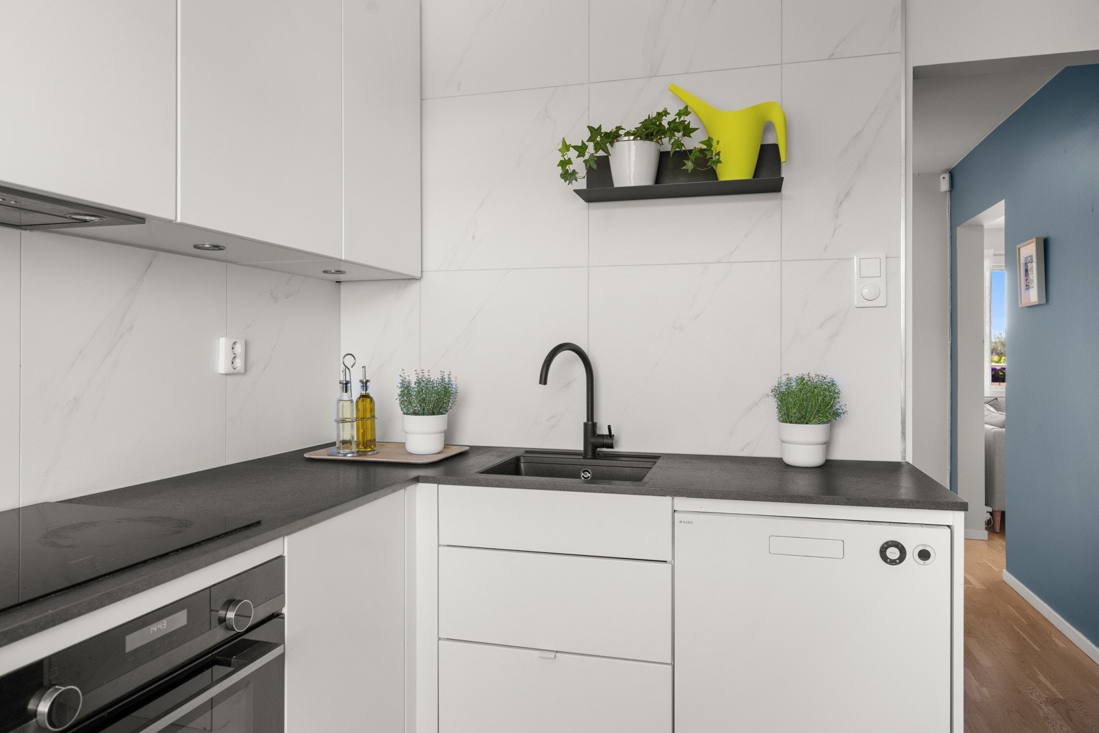 Stilrent kjøkken med slette fronter, laminat benkeplate og lekre fliser over benk. Galleribilde