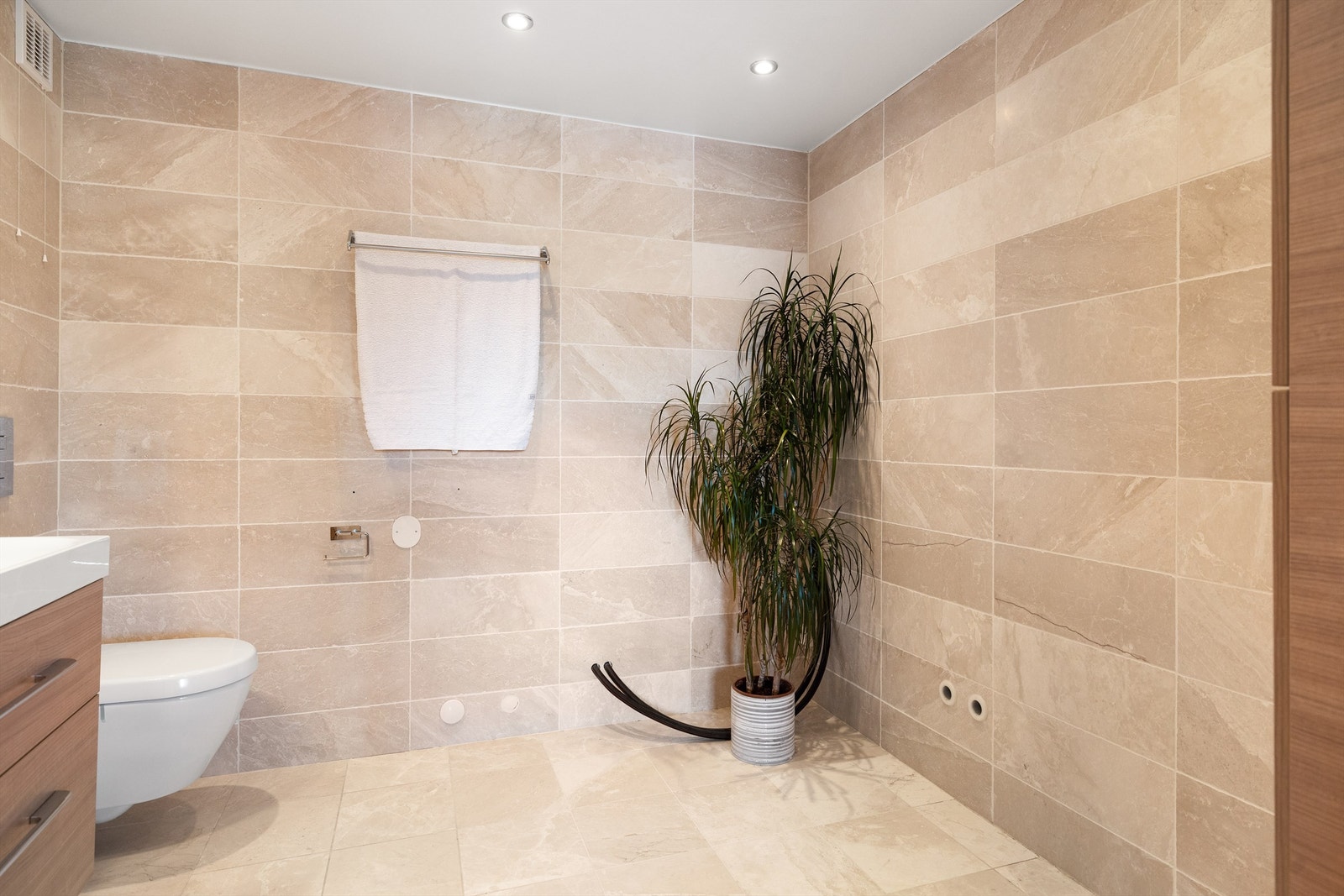 Badet består av vegghengt servantskap med glatte fronter, nedsenket servant, vegghengt speilskap med overbelysning og vegghengt toalett. Nedsenket himling med malt flate og downlights. Galleribilde