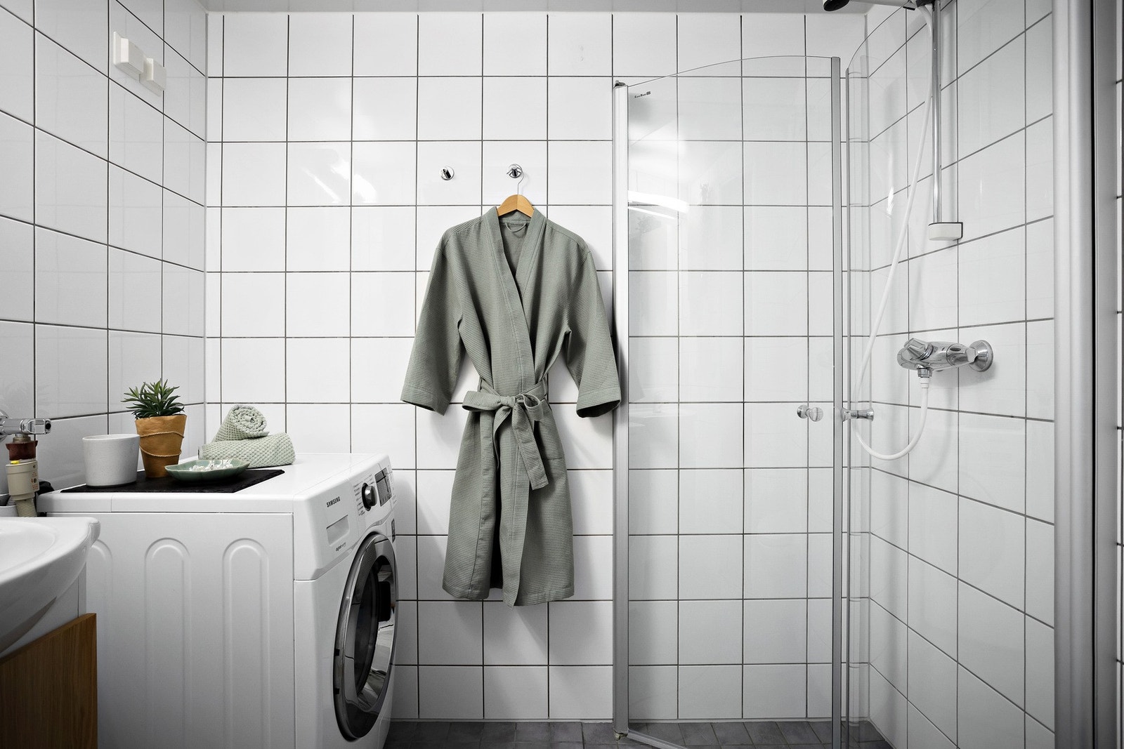 Badet er utstyrt med vegghengt servantskap med ovenpåliggende servant med ett-greps armatur. Det er innfelt speil og belysning med stikkontakt samt vegghengt skap over servant. Galleribilde