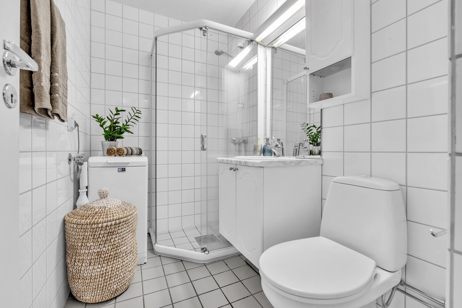 Lyst og pent baderom med fliser på vegger og gulv, med underliggende gulvvarme. Galleribilde