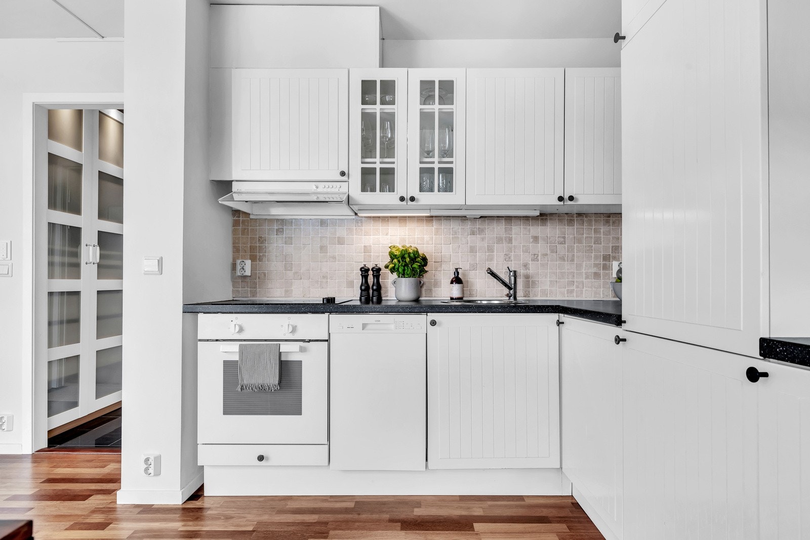 Hvite fronter, lamiant benkeplate og integrerte hvitevarer. Galleribilde