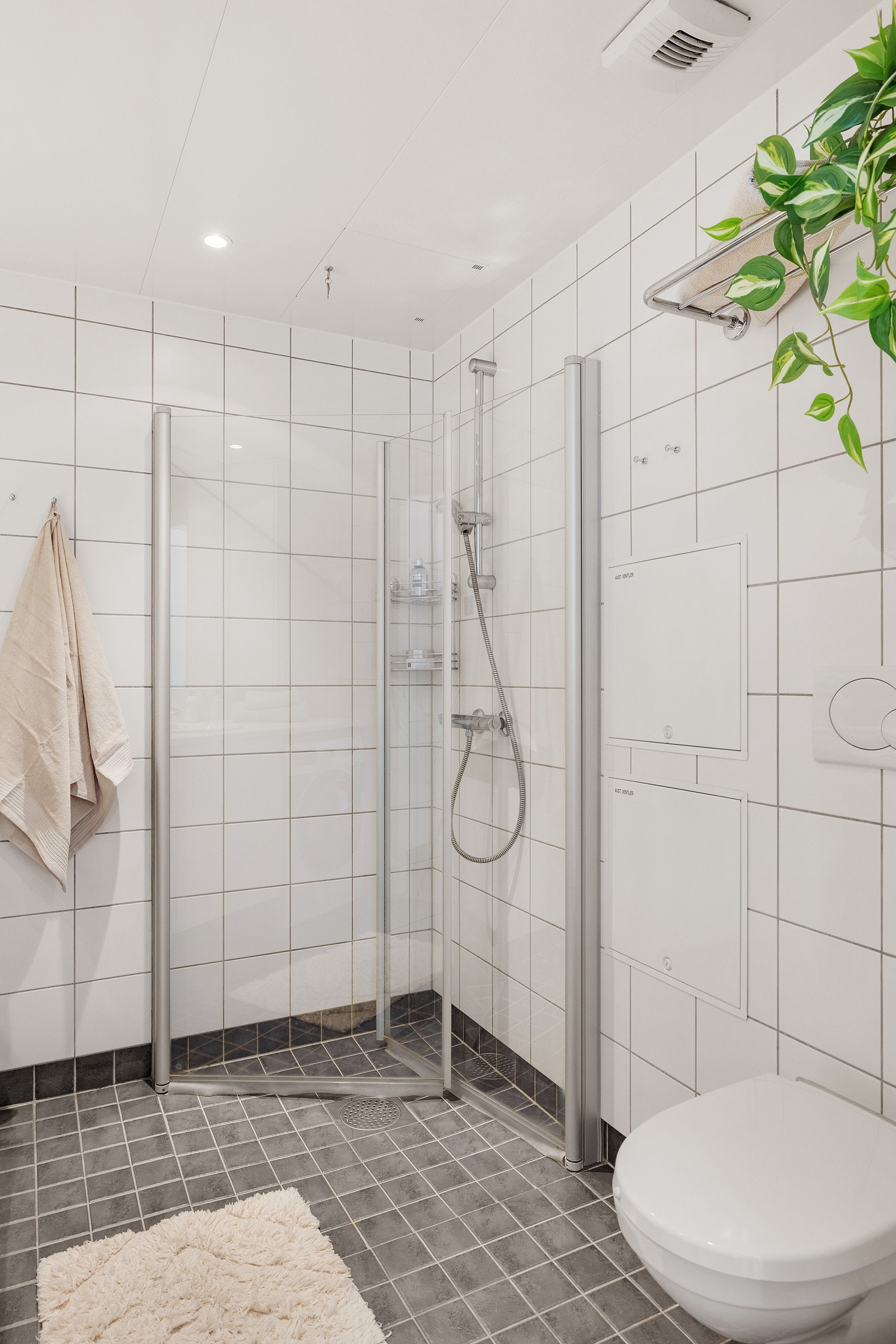 Et lyst og lekkert bad med eget dusjhjørne og vegghengt toalett. Galleribilde