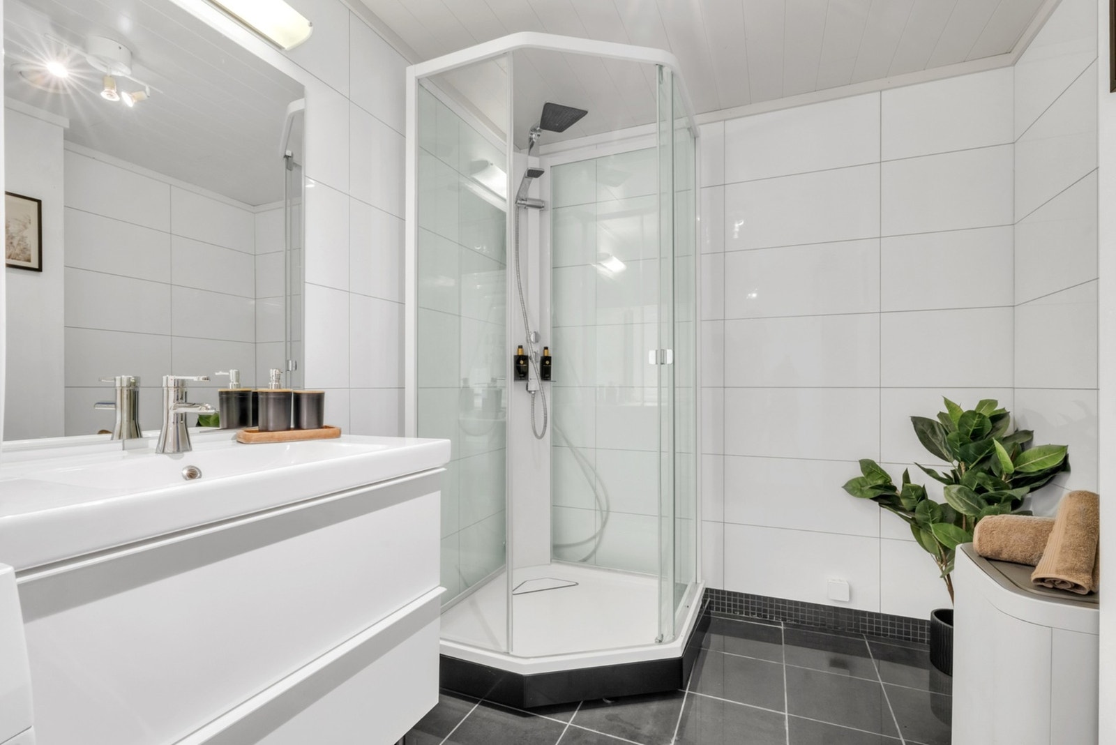 Badet er utstyrt med lukket dusjkabinett og har opplegg for vaskemaskin. Galleribilde