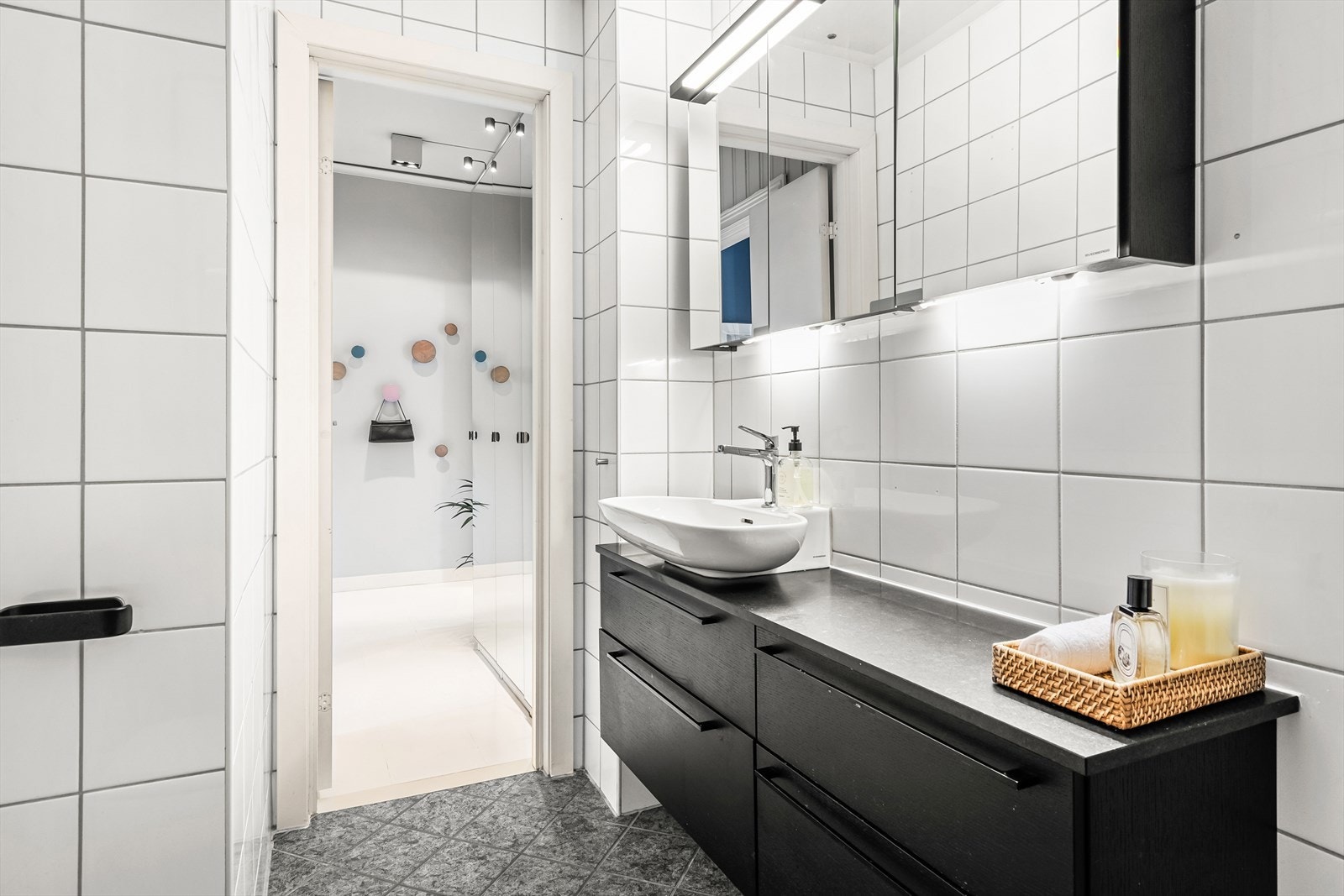 Badet er innredet med vegghengt klosett, servant på innredningen, speilskap med lys og dusjhjørne med svingbare glassdører. Det er opplegg for vaskemaskin og rommet har naturlig avtrekk. Galleribilde