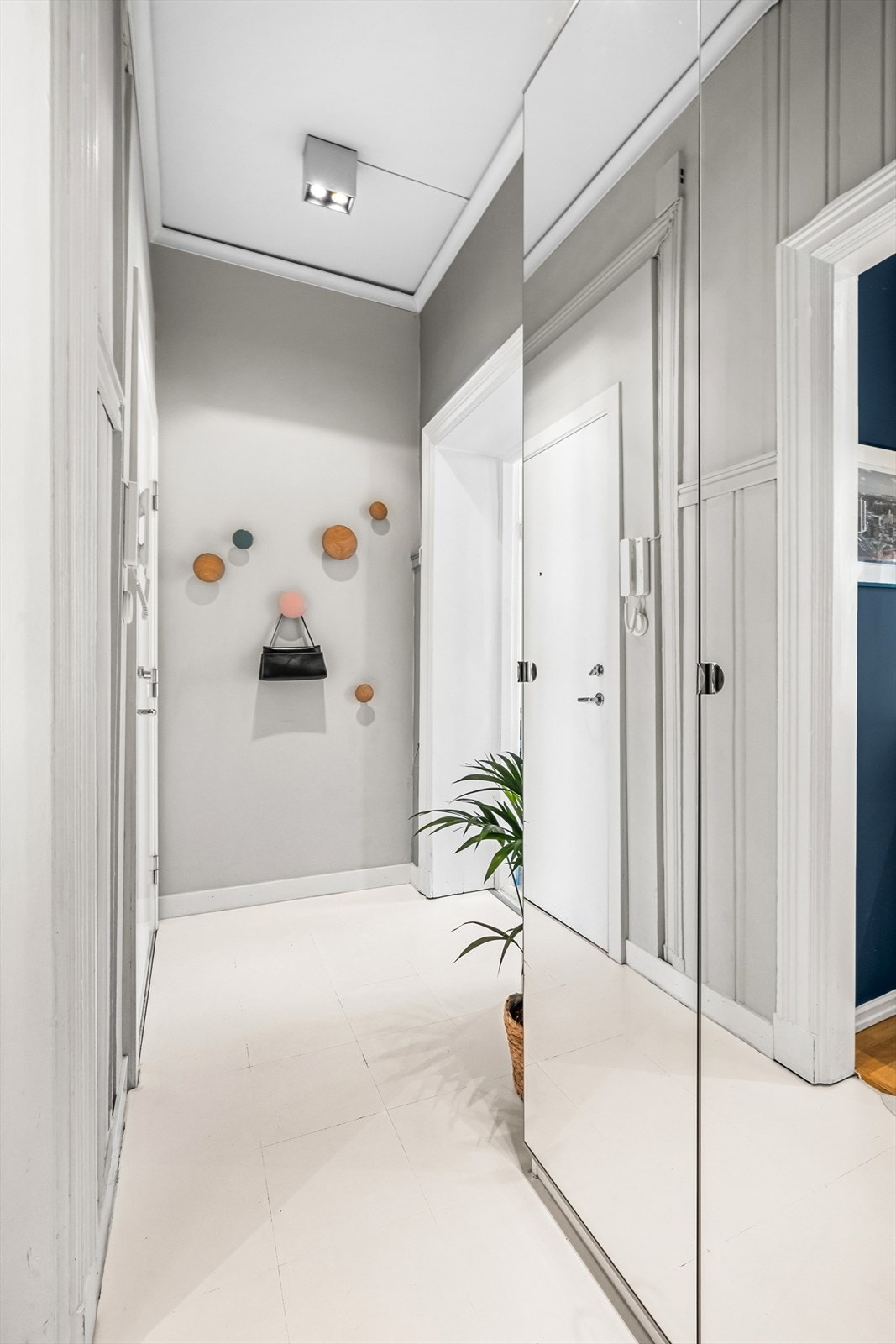 Leiligheten har en innbydende entré som skaper et umiddelbart godt førsteinntrykk. Det er god plass til oppbevaring av yttertøy og sko i garderobeskapet med speilfronter. Galleribilde