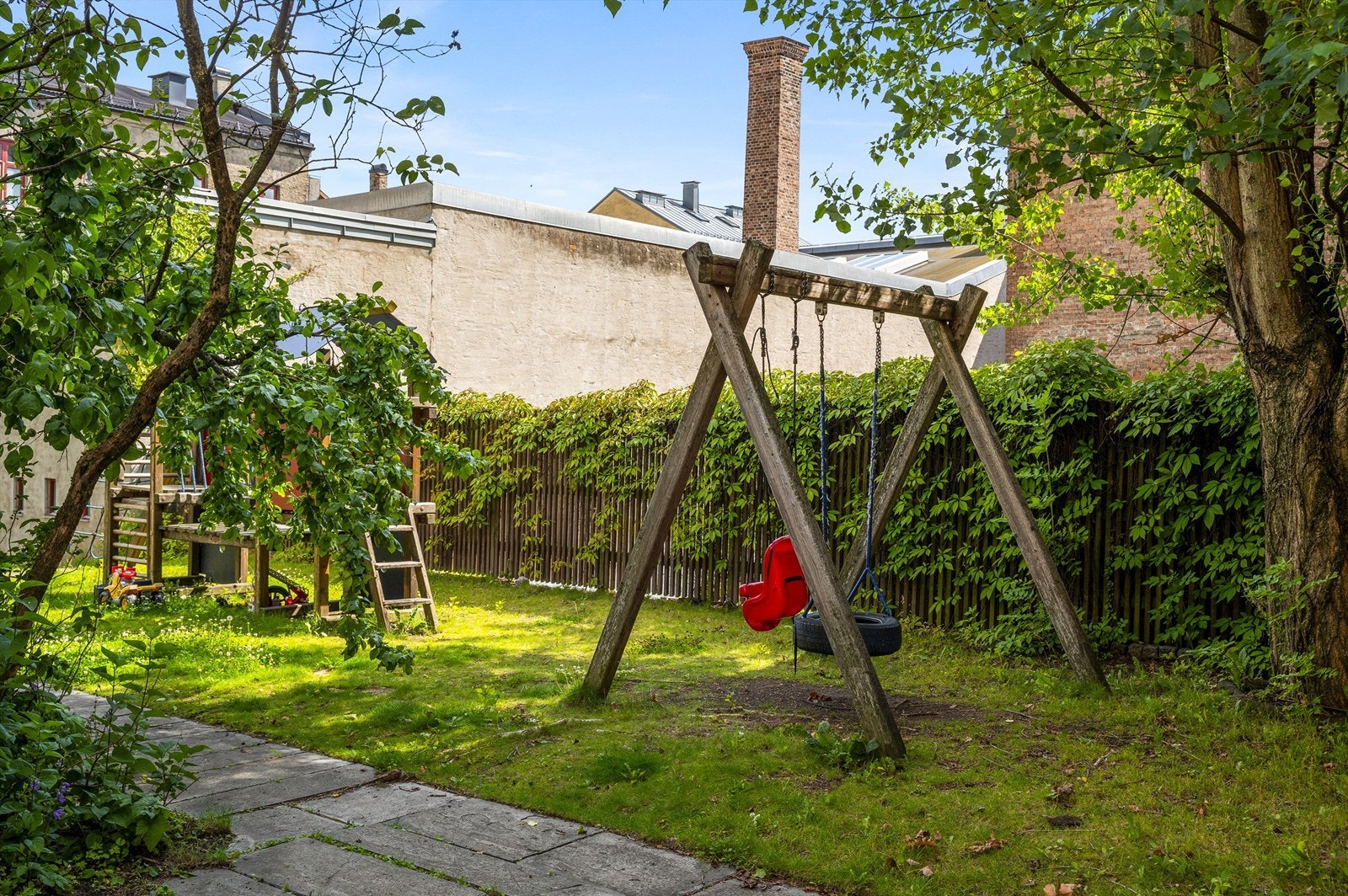 Veldig hyggelig og skjermet bakgård med hellelagt uteplass, plen og beplantning, samt sittegrupper og lekeutstyr. Galleribilde
