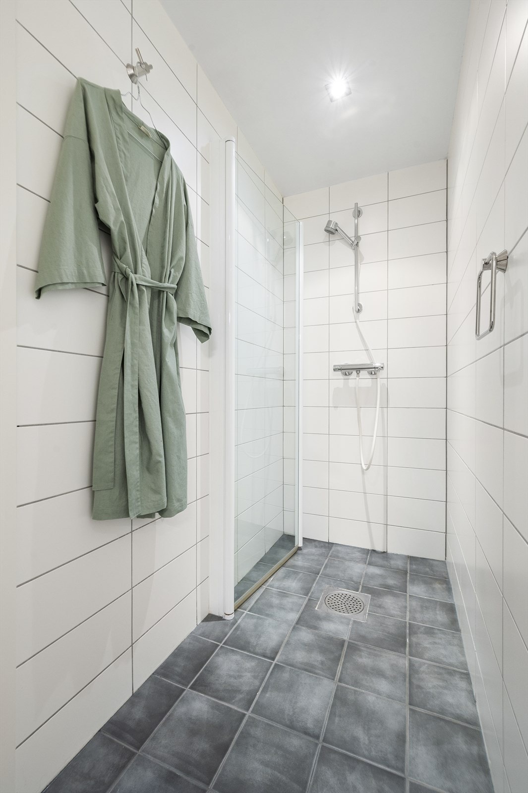 Videre har badet både badekar og dusjhjørne med innfellbar glassdør. Galleribilde