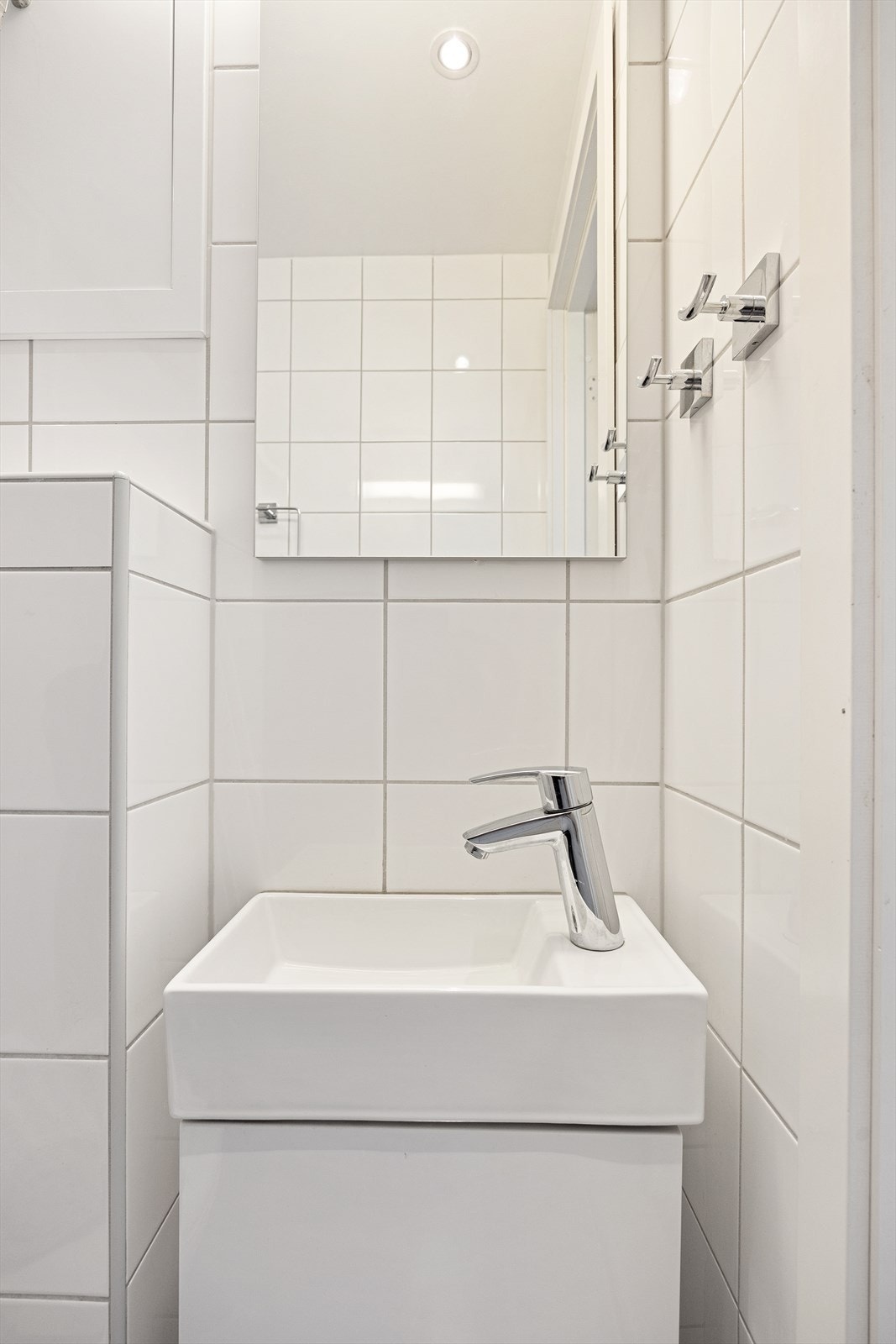 Badet består av veggmontert wc, dusjplass med vegger og servant med ettgreps blandebatteri. Galleribilde