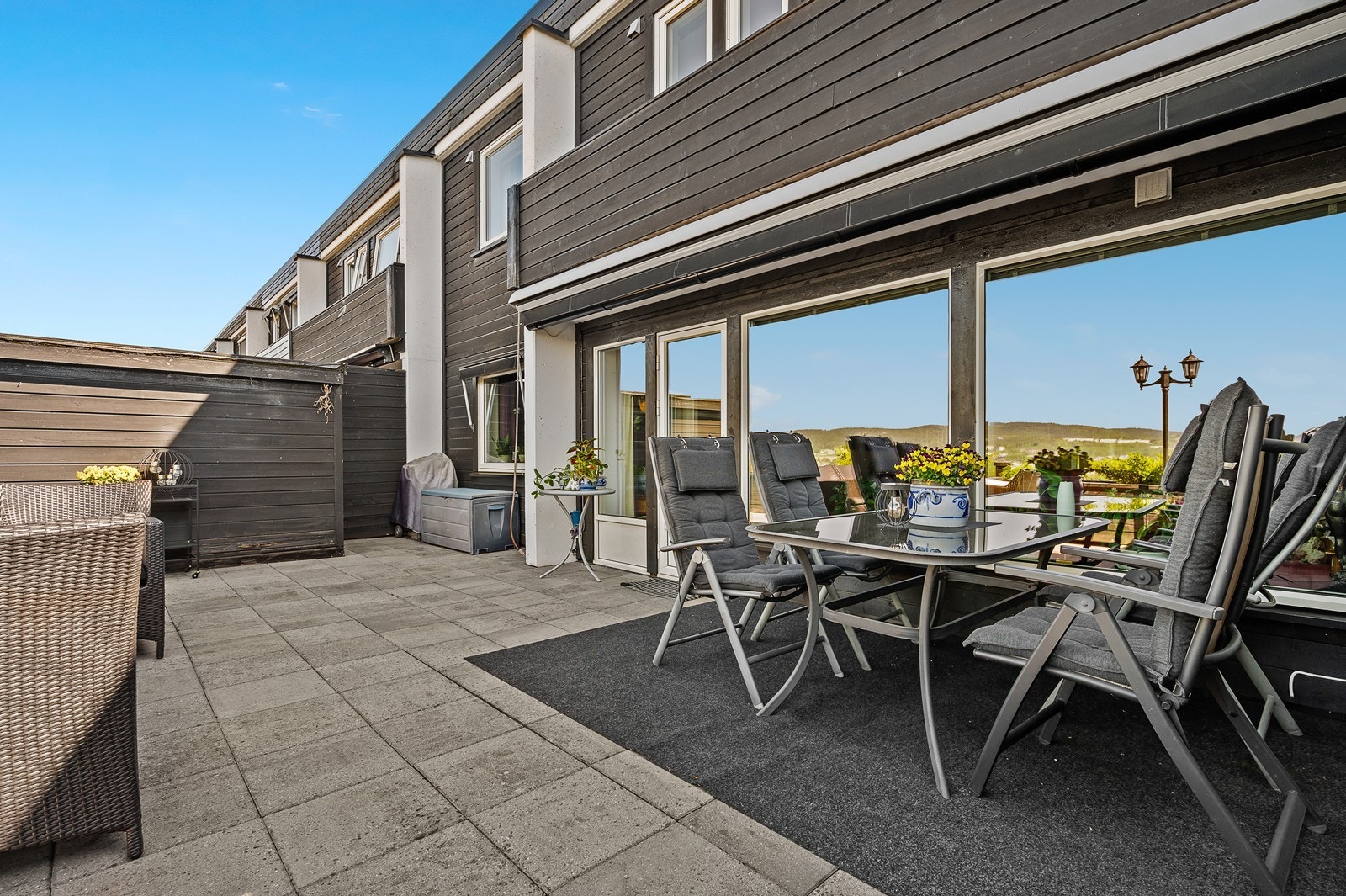 Svært romslig steinlagt terrasse med terrassemarkise Galleribilde