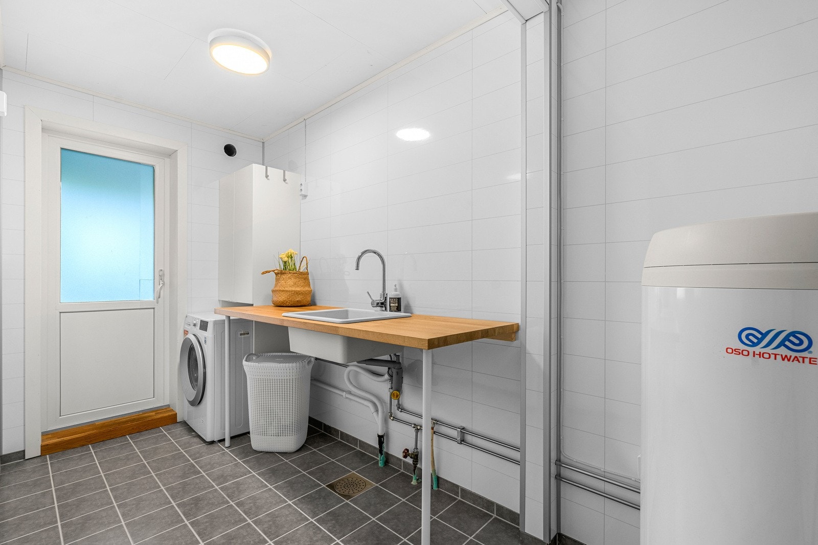 Boligen har eget praktisk vaskerom med utgang til hagen Galleribilde