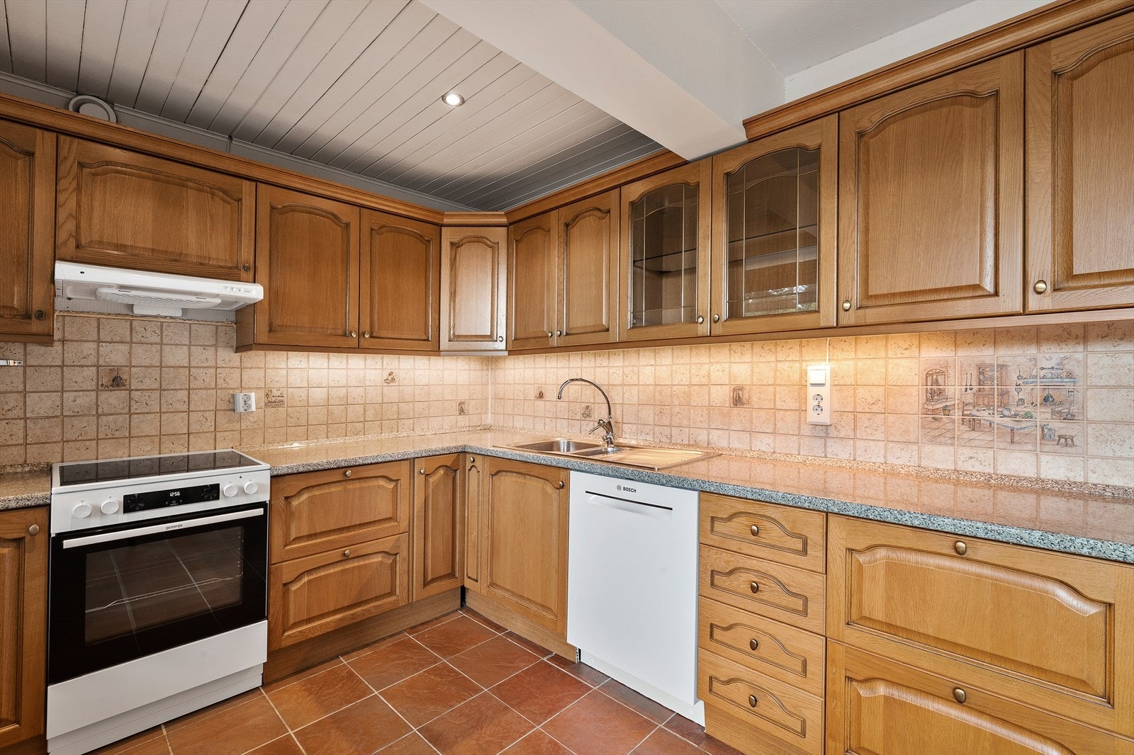 Kjøkkeninnredning med profilerte fronter og laminat benkeplate med nedfelt kum i rustfritt stål. Opplegg for oppvaskmaskin. Galleribilde