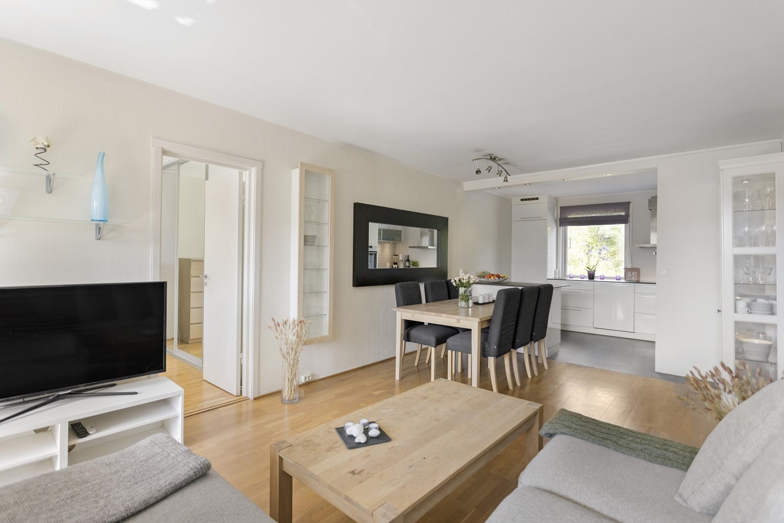 Stue med store vindusflater, parkett på gulv og utgang til balkong Galleribilde