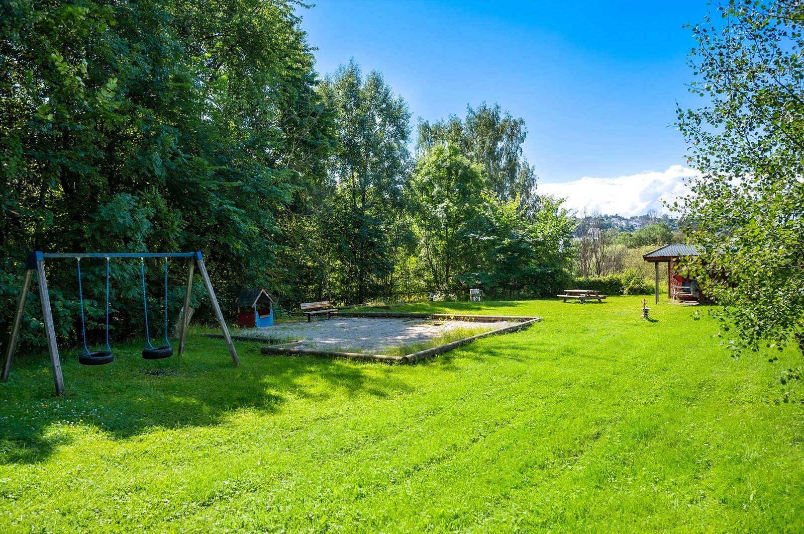 Området inkluderer en velutstyrt lekeplass med både husker, sandkasse og dukkestue Galleribilde