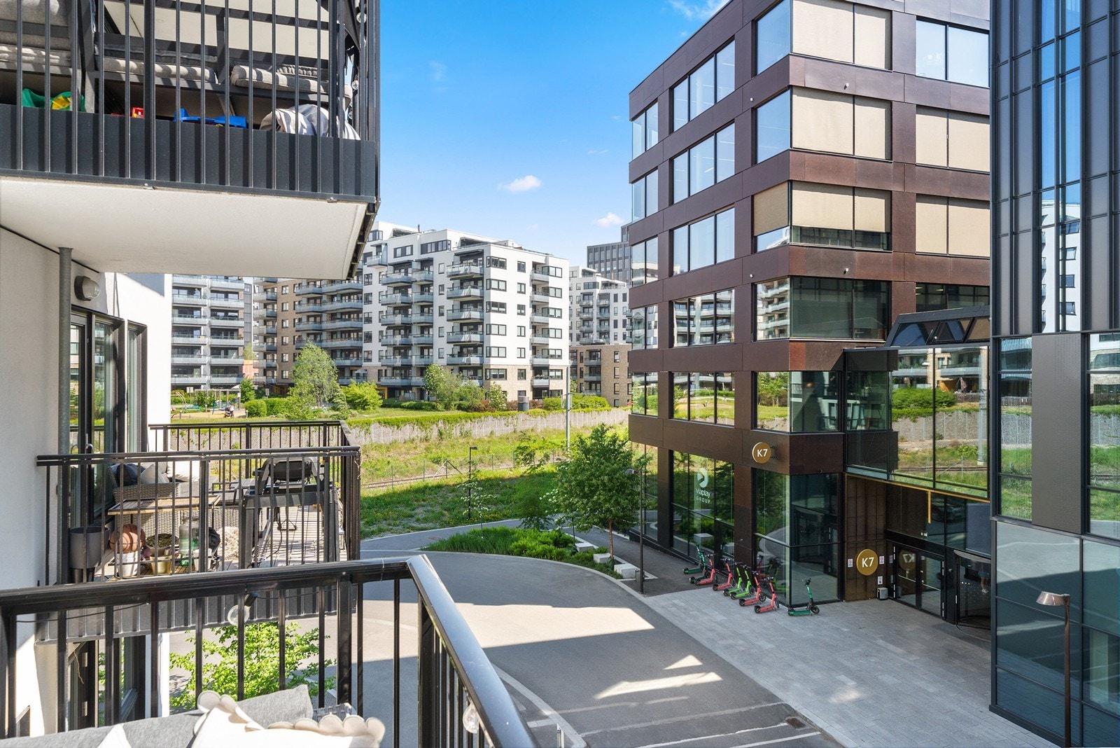 Balkong med utsikt over grøntområde og moderne bygg Galleribilde