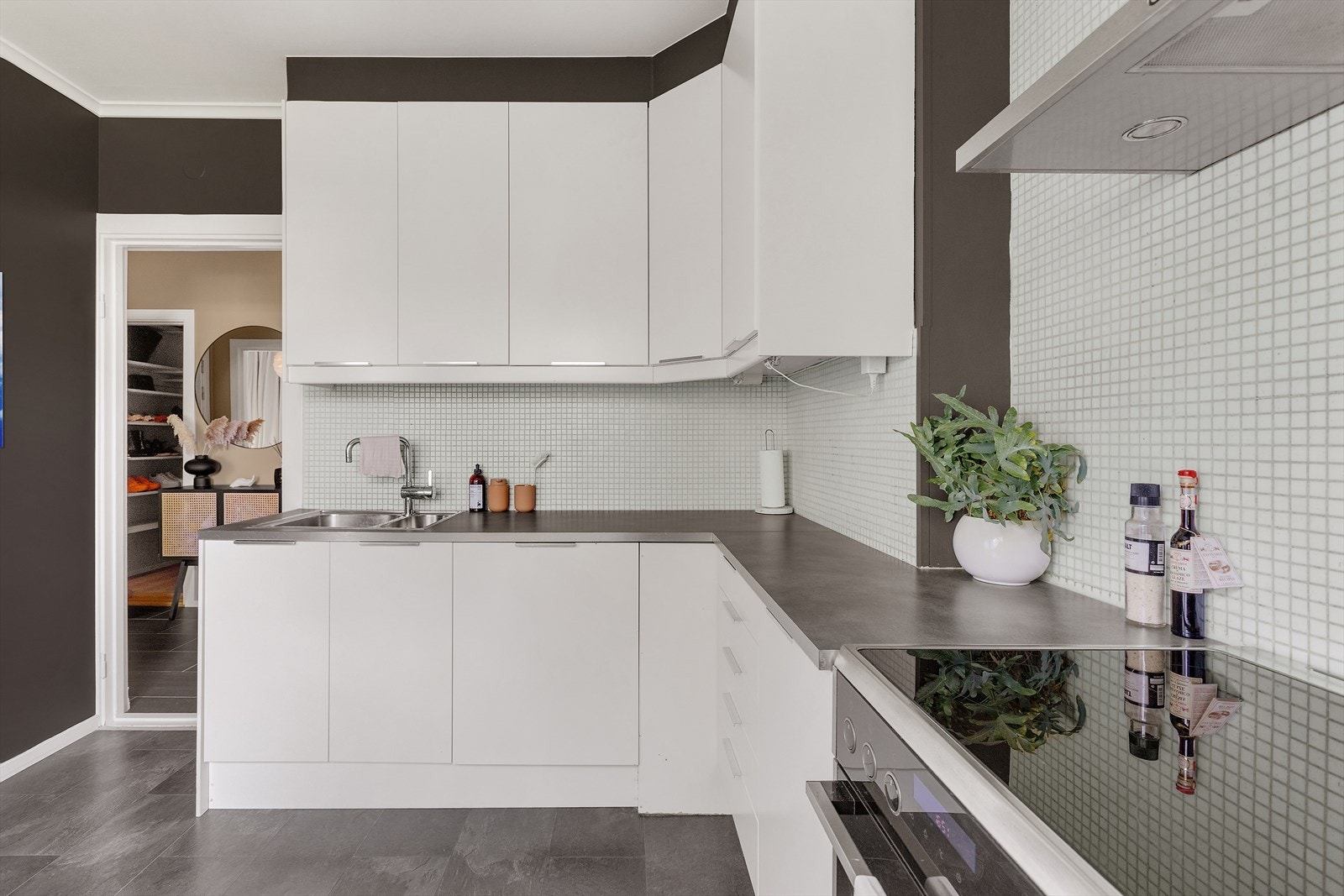 Innredningen er lys og har glatte fronter med ledlys under overskap. Laminat benkeplate og mosaikkfliser i benkerygg. Galleribilde