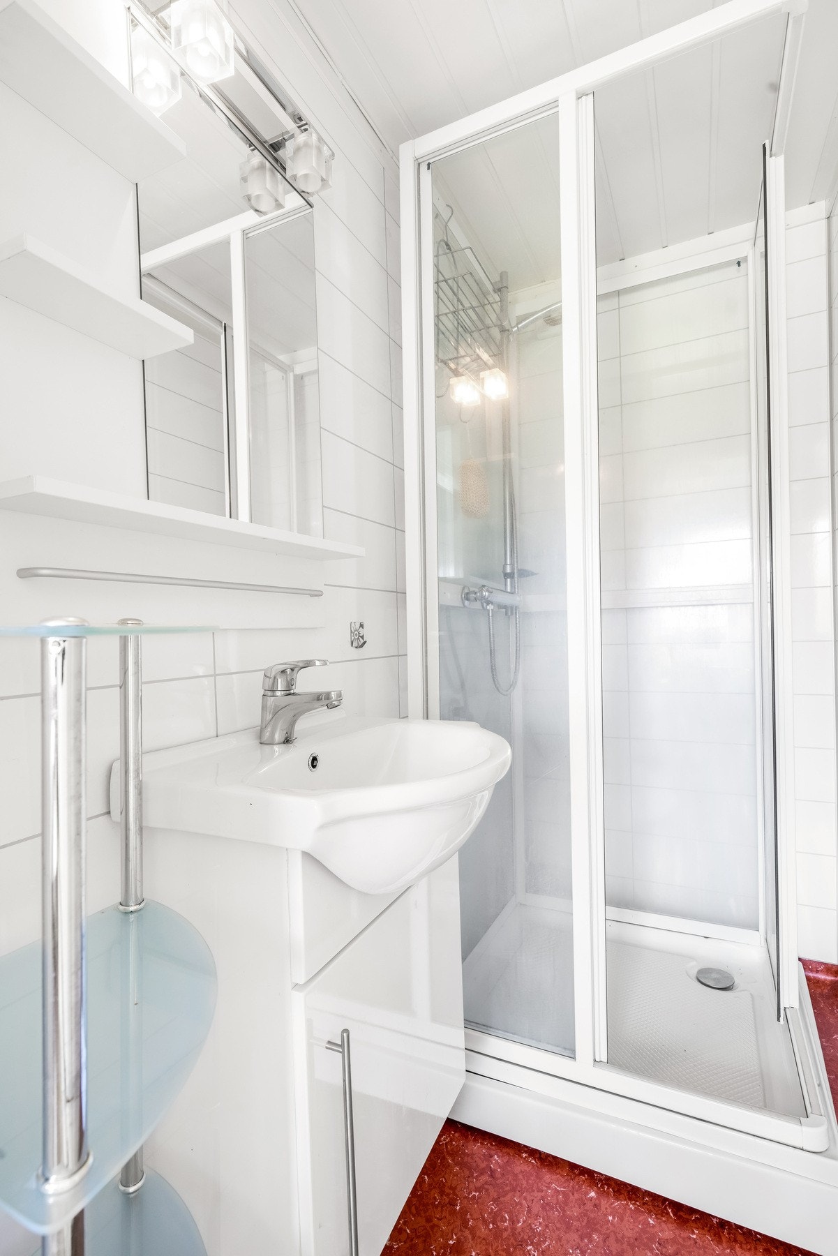 Badet er separat fra toalettrommet og er plassert ved kjøkkenet og spisekroken. Gulvet har belegg, veggene har hvite baderomsplater og himlingen har hvit panel. Galleribilde