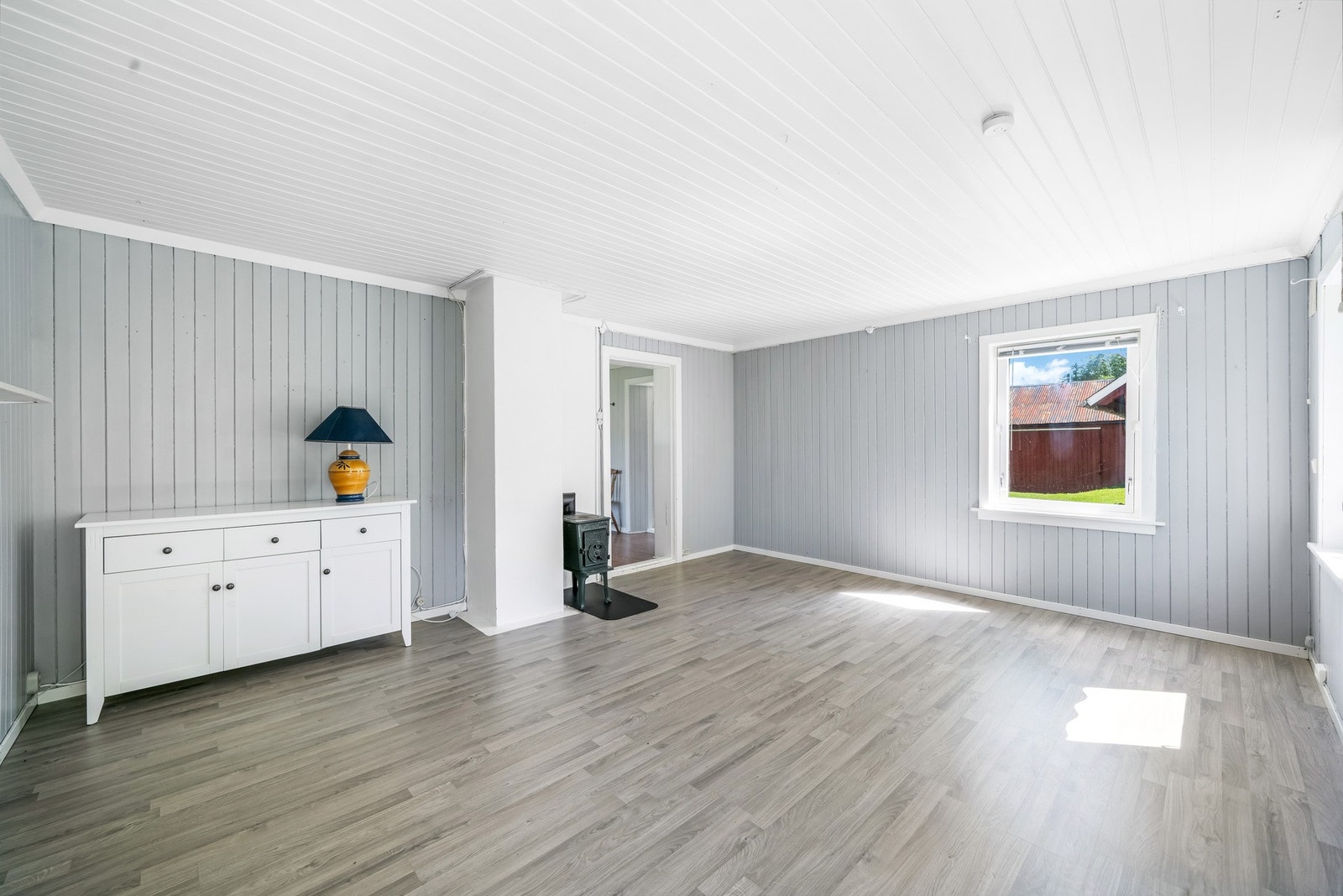 Pusset teglsteinspipe fra ukjent årstall og vedovn. Fra stuen har man oversikt over tunet. Galleribilde