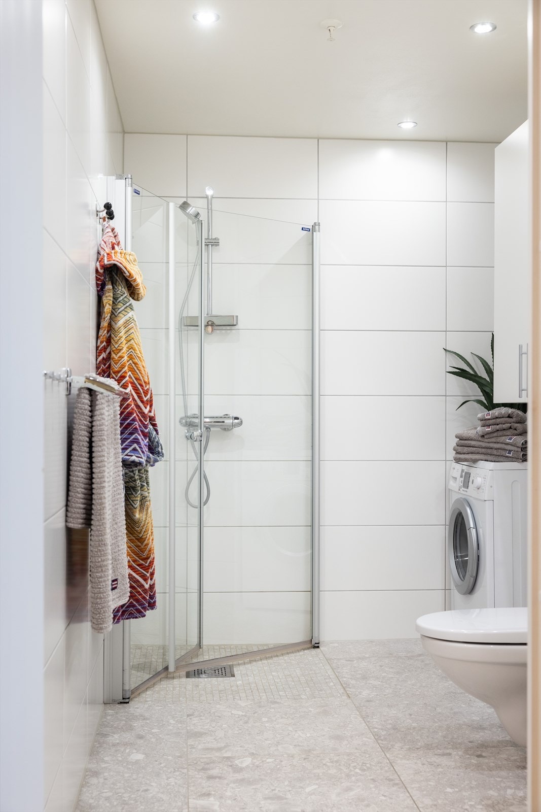 Innredningen består av servantskap, speil, vegghengt skap, vegghengt toalett og dusjhjørne med innfellbare glassdører. Galleribilde