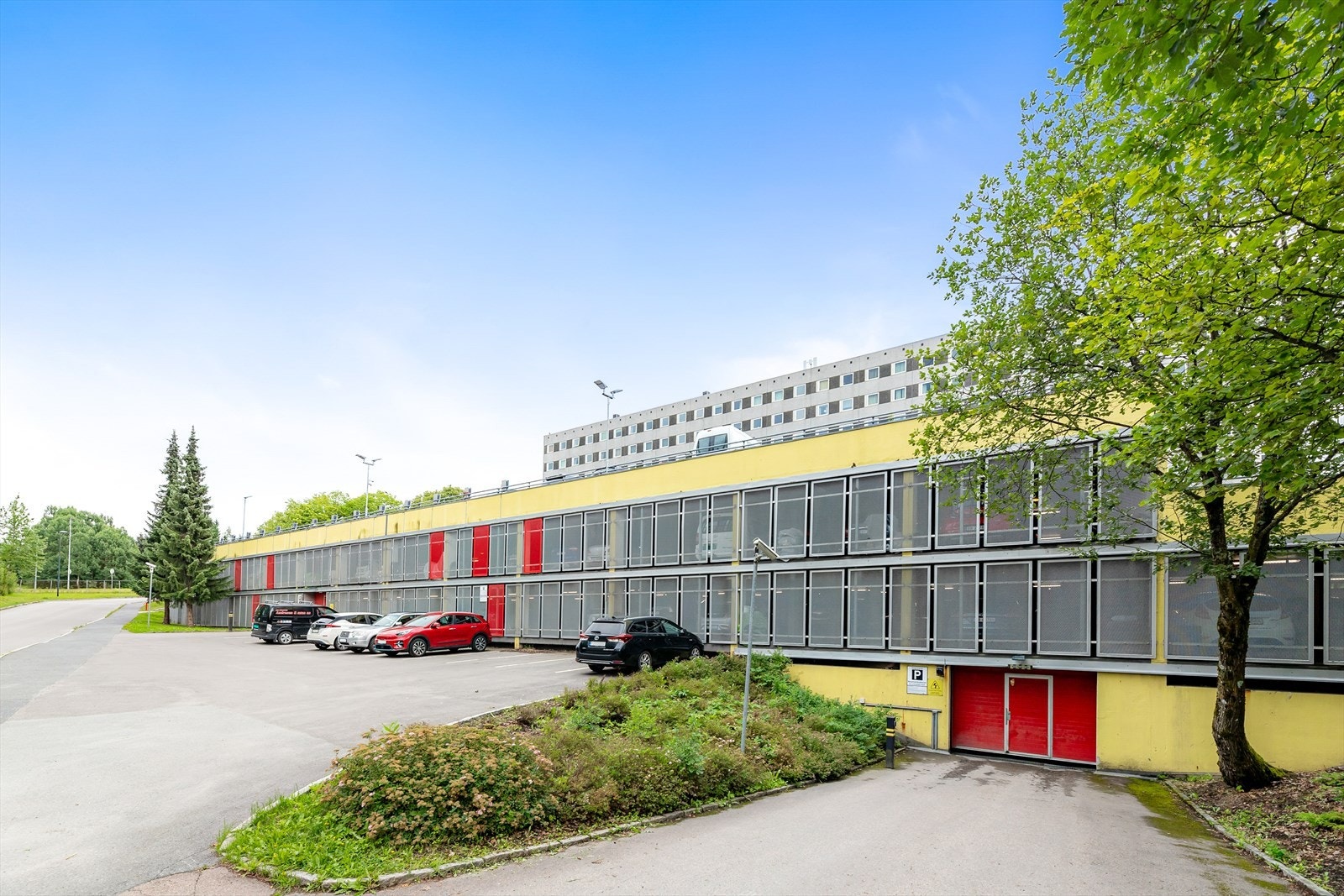 Parkeringsplass og inngangsparti til bygget. Galleribilde