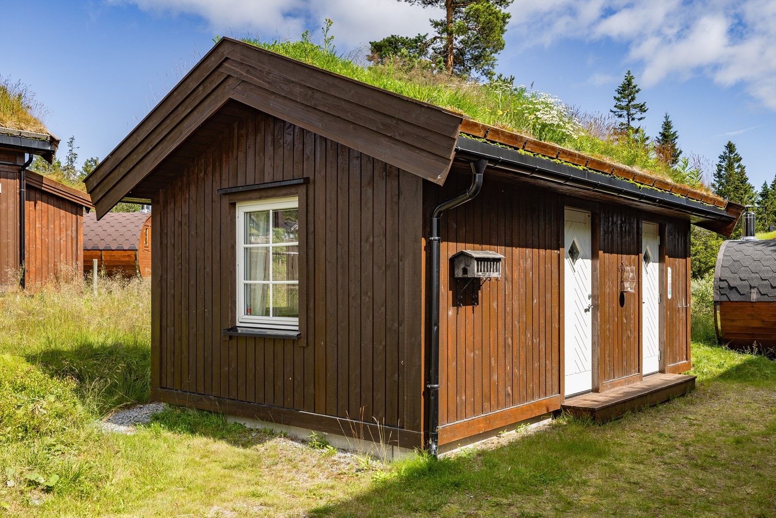 Det er godt med biloppstillingsplasser på tomta. I tillegg til hytta består eiendommen av et anneks og badstue. Galleribilde