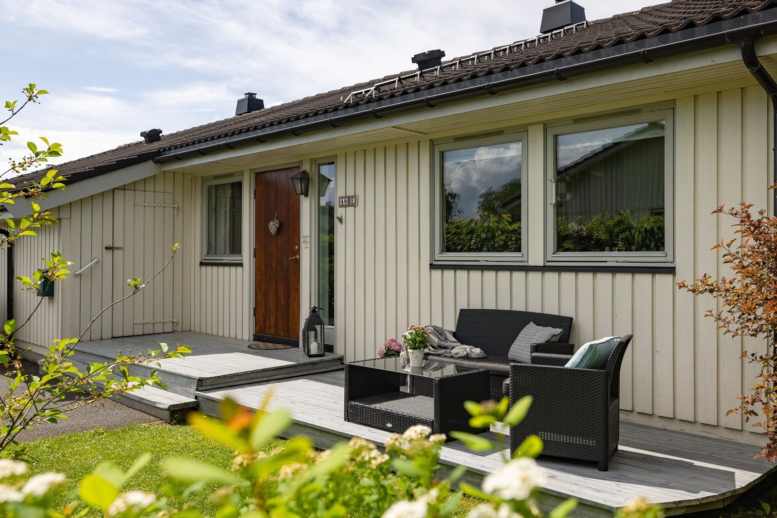 Overbygd inngangsparti, med både bod og en koselig platting rett på utsiden av døra. Galleribilde