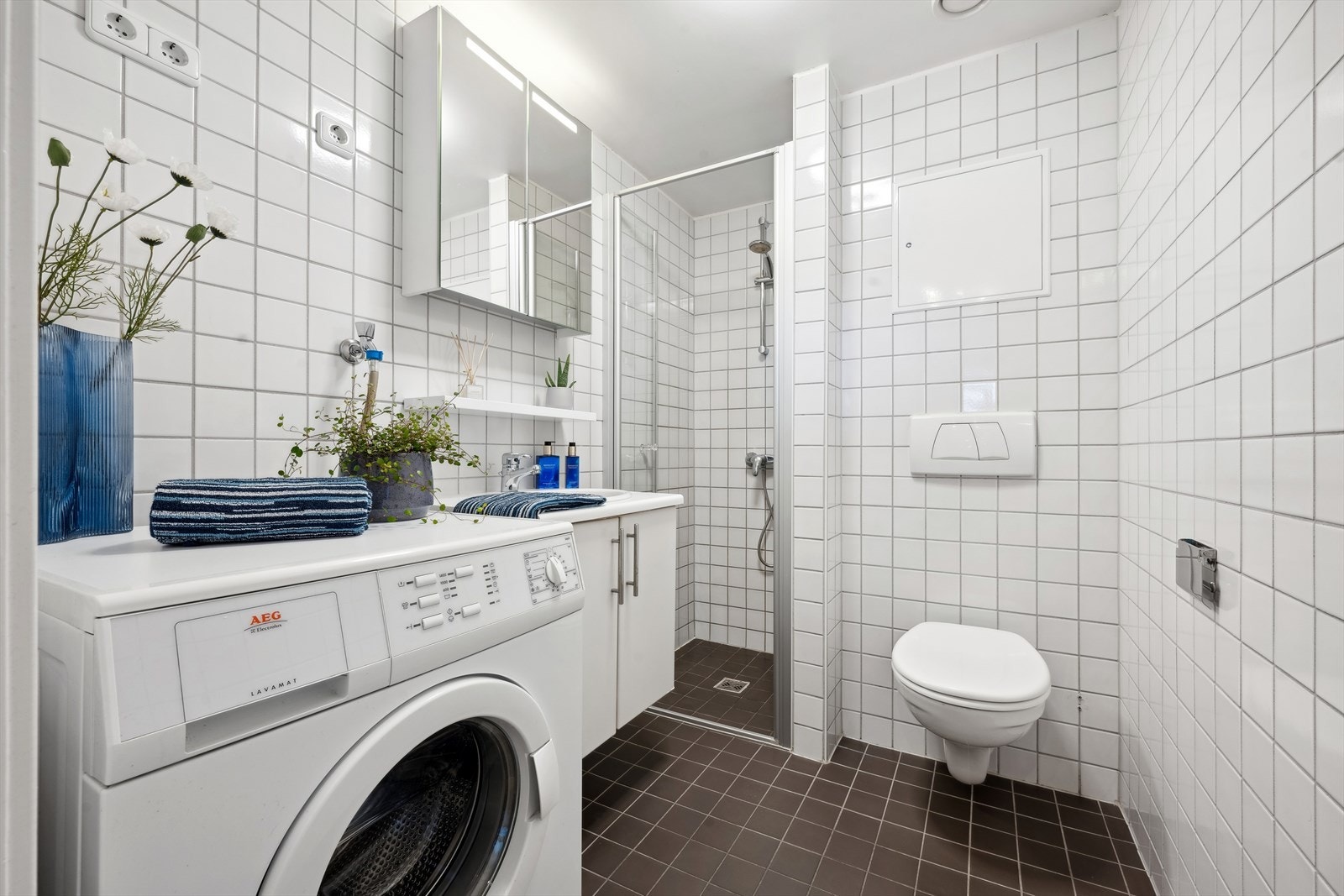 Lyst, flislagt bad med varmekabler i gulv. Det er opplegg for vaskemaskin. Galleribilde