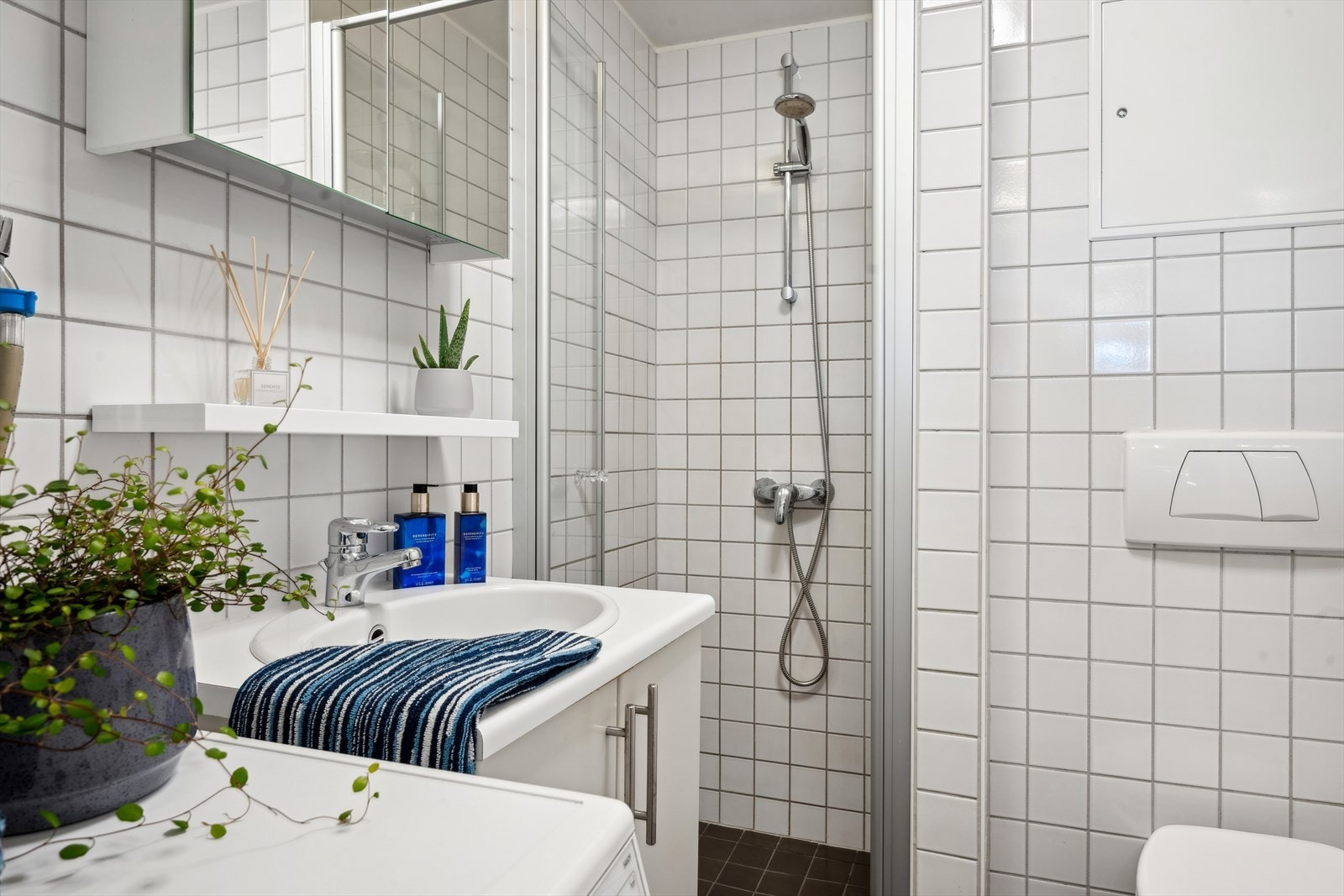 Rommet består av baderomsinnredning, dusjhjørne og vegghengt toalett. Galleribilde