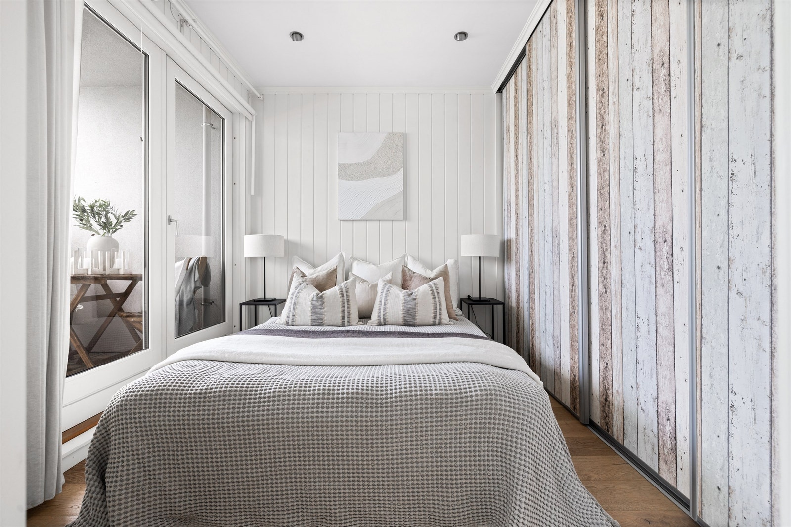 Innred soverommet med dobbeltseng og tilhørende nattbord på hver side. Galleribilde