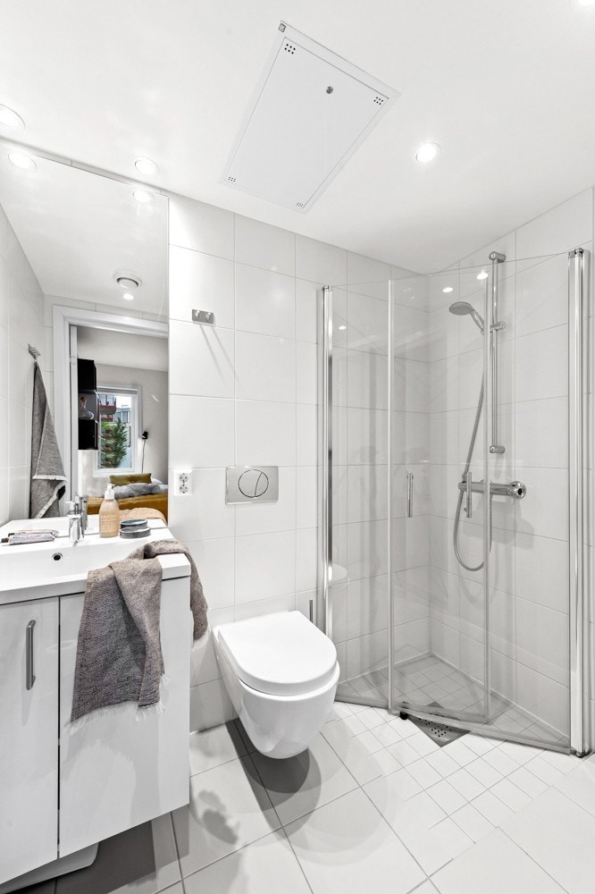 Helfliset baderom med varme i gulv og downlights i himling Galleribilde