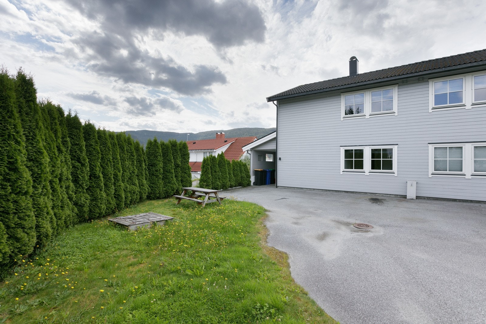 Asfaltert innkjørsel og parkering på tomten. Galleribilde