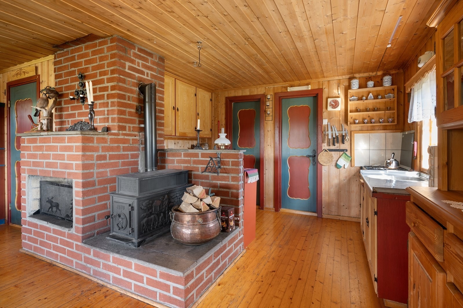 Innenfor kjøkkenet er det to soverom. Mellom stue og kjøkken er det en stor og god vedovn/peis. Galleribilde