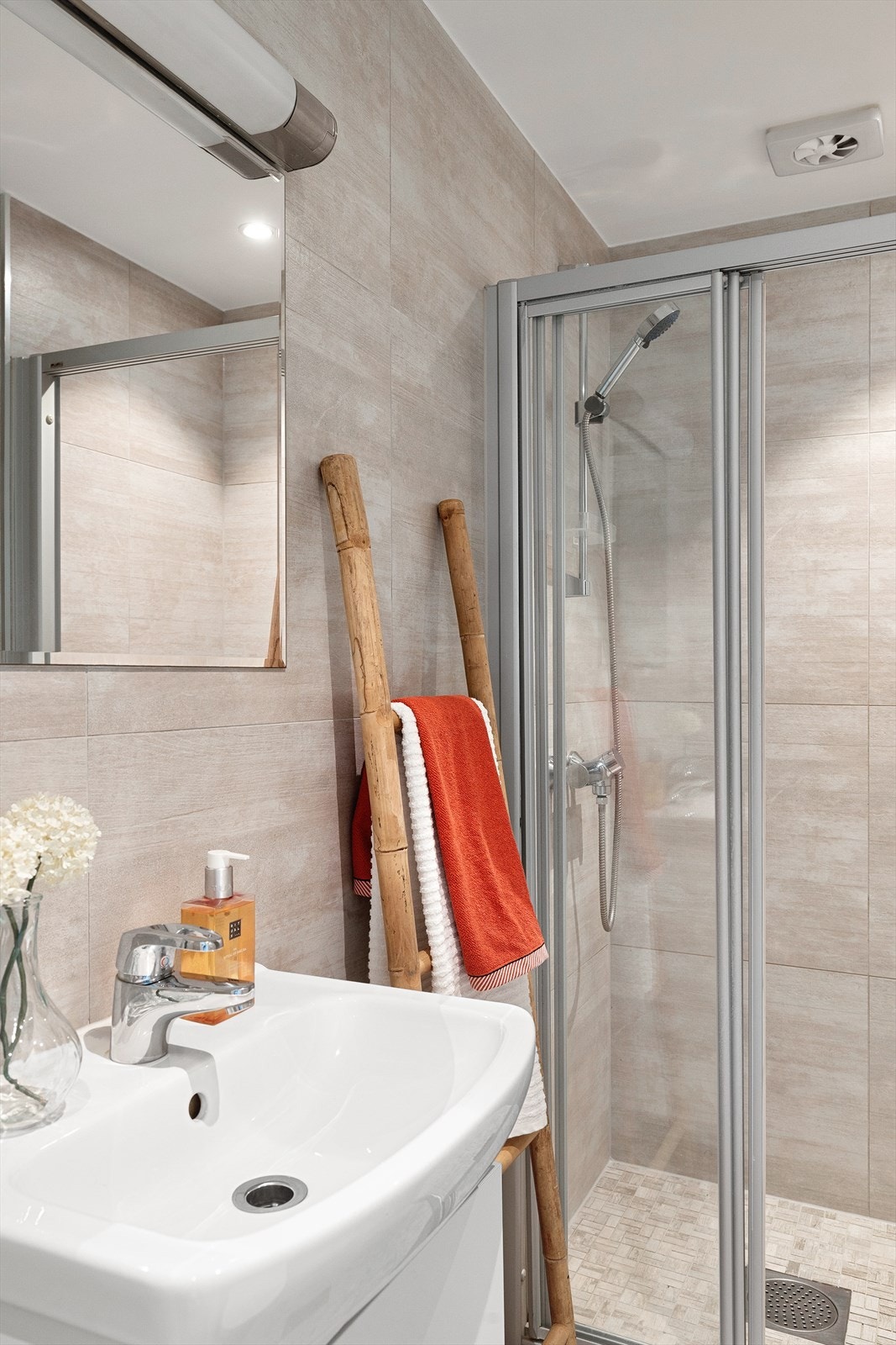 badet inneholder servant med underskap, toalett, dusj med skyvedør og opplegg til vaskemaskin Galleribilde