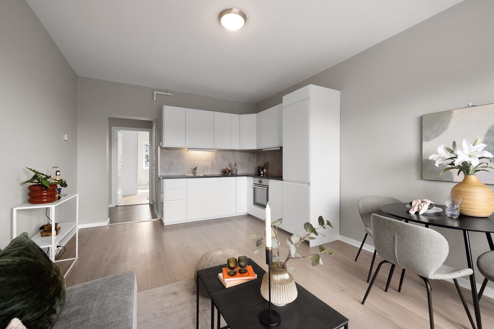 Leiligheten har et stilrent kjøkken med hvite slette fronter Galleribilde