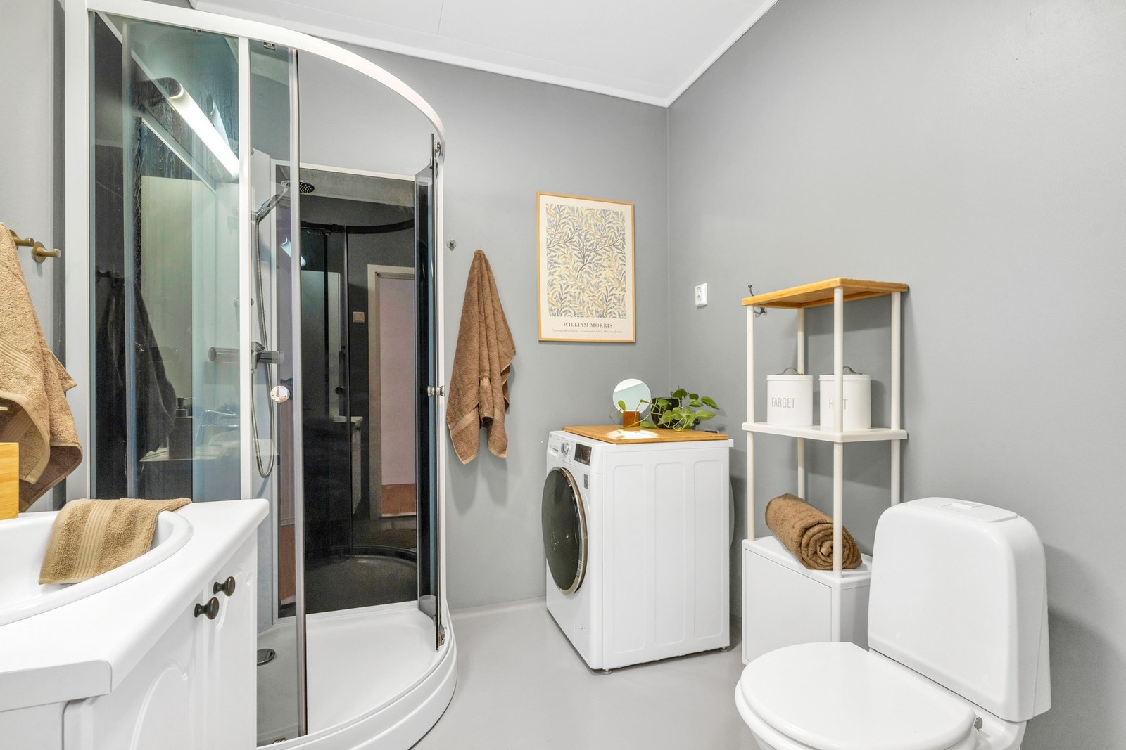 Veggmontert dusjgarnityr og gulvmontert WC, og innredet kran og avløp for vaskemaskin. Galleribilde