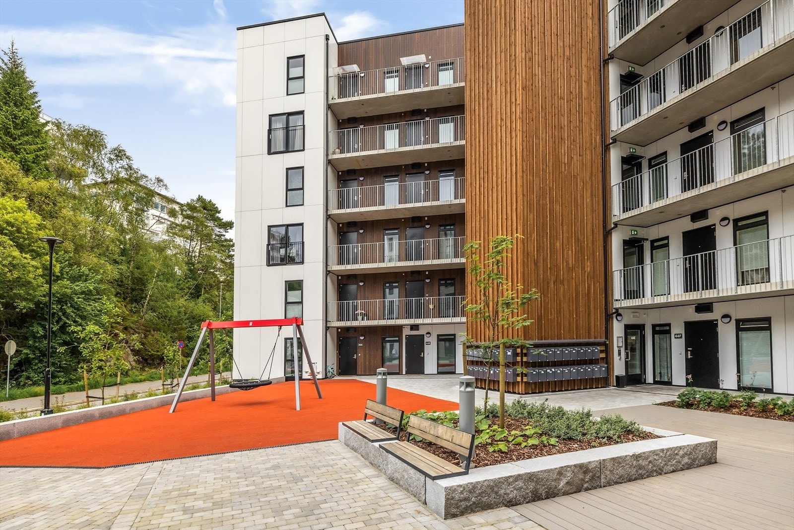 Fellesarealet er pent opparbeidet med sittegrupper, beplantning og lekeplass. Galleribilde