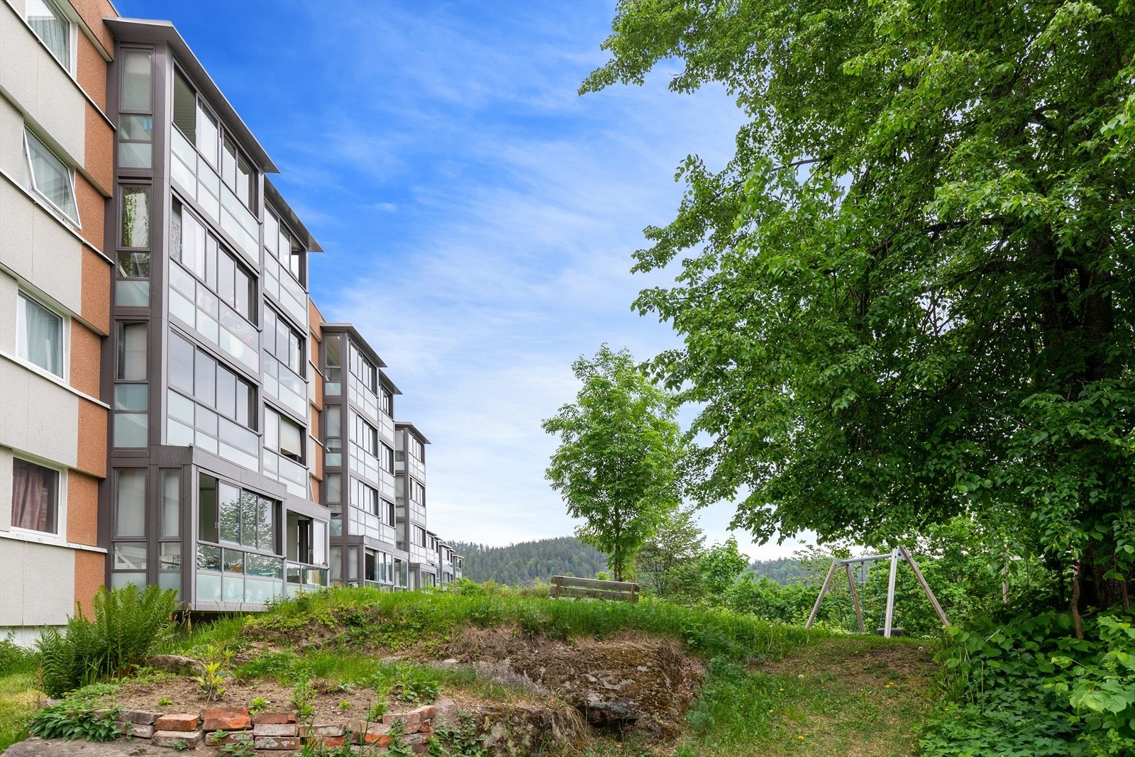 Felles uteareal er pent opparbeidet med gressplen og lekeplass Galleribilde