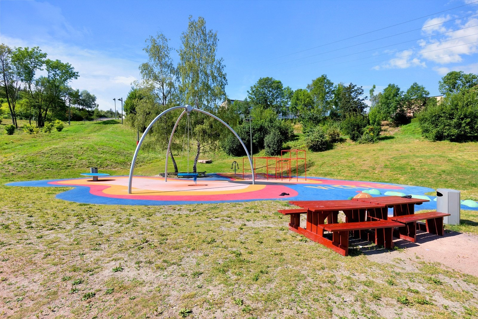 Her er det også lekeplass med elementer som multisvingehuske, karusell, parkour og sandlek Galleribilde