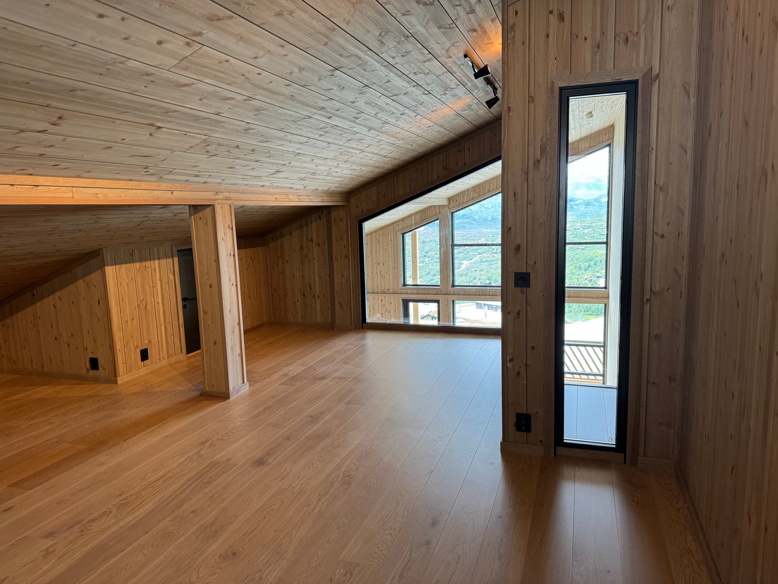 Loftstue har også fantastisk utsikt gjennom stort vindu i veggen mot stue. Galleribilde