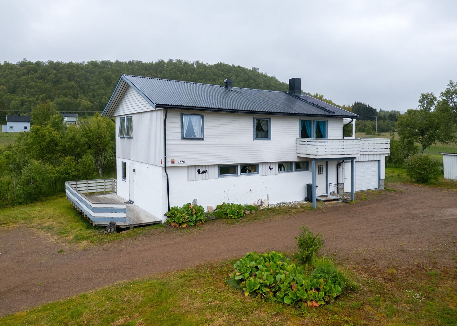 Boligens uteområde er opparbeidet med stor gruslagt gårdsplass Galleribilde