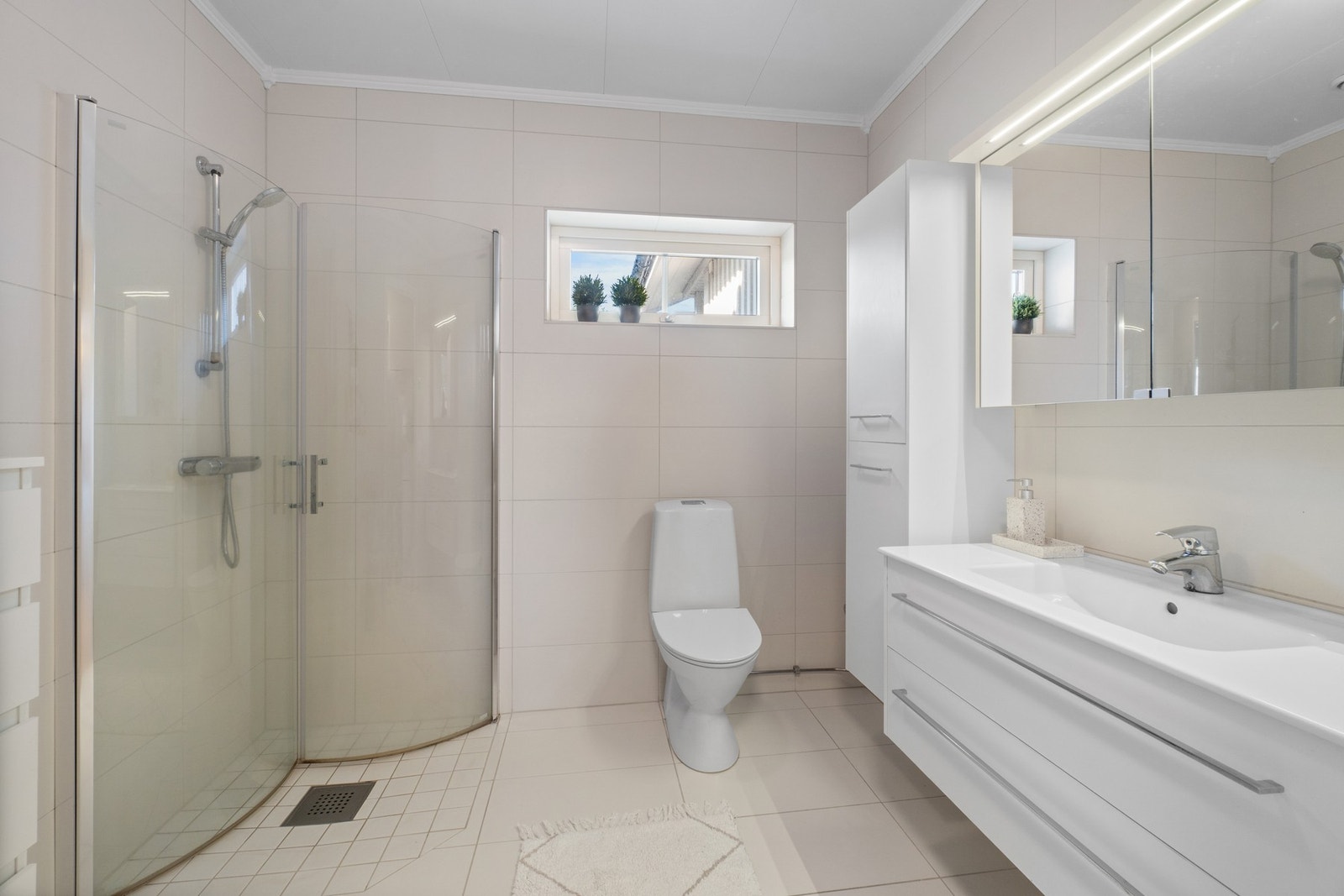 Badet har et moderne uttrykk, gulvvarme og en stor innredning. Galleribilde