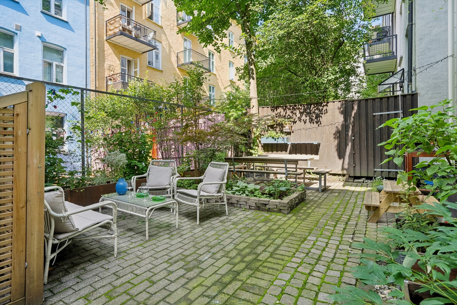 Hyggelig felles avlukket bakgård med beplanting, sittegruppe og sykkelstativ Galleribilde