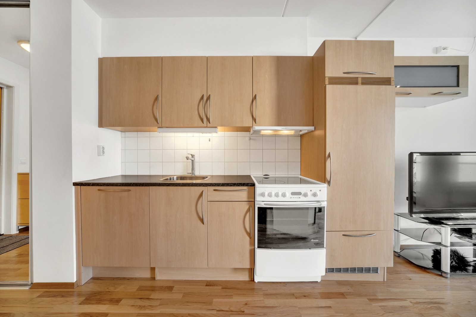 Stilrent kjøkken med flislagt bakvegg. Galleribilde