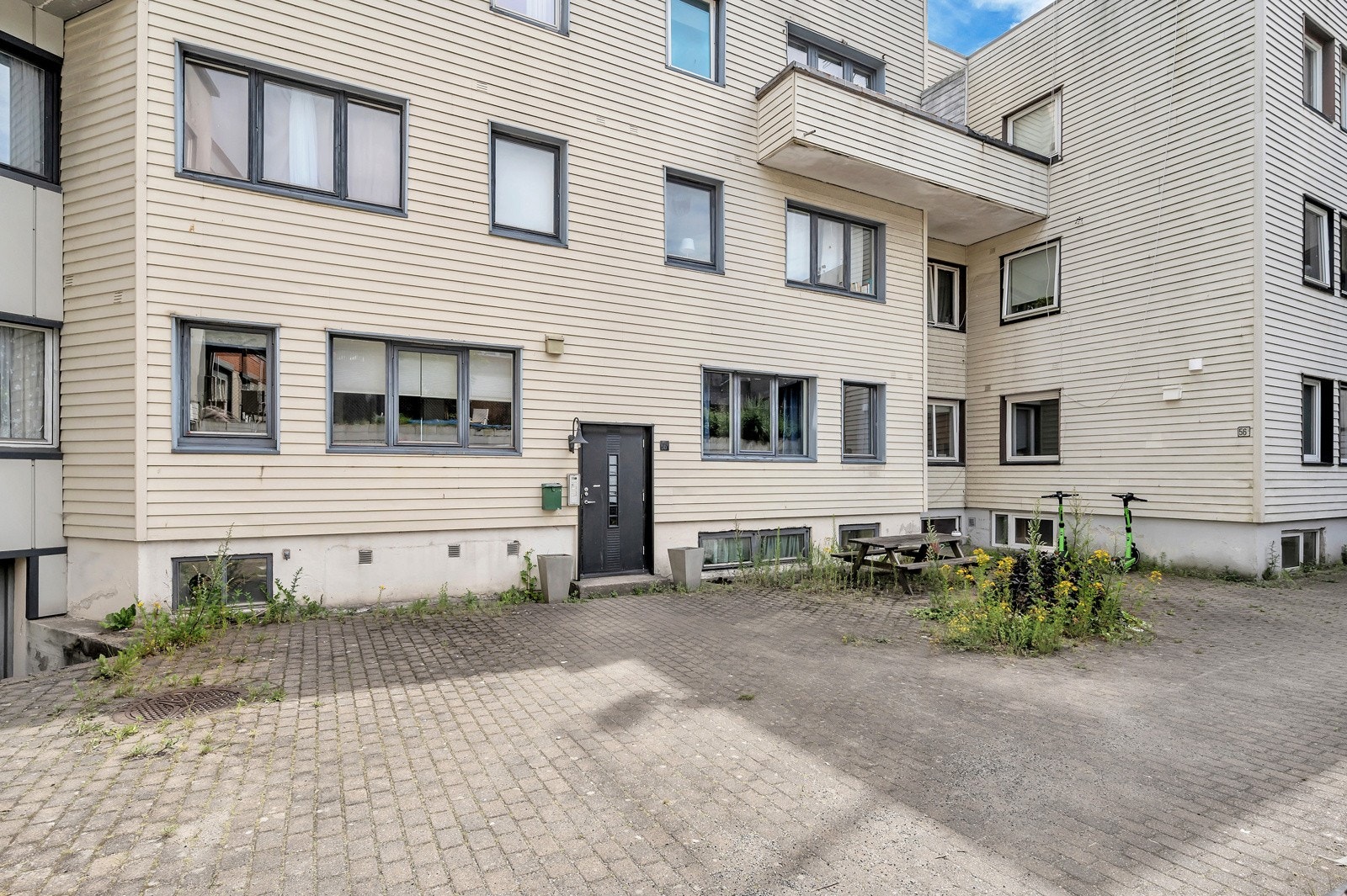 Indre gårdsrom med felles inngangsdør. Galleribilde