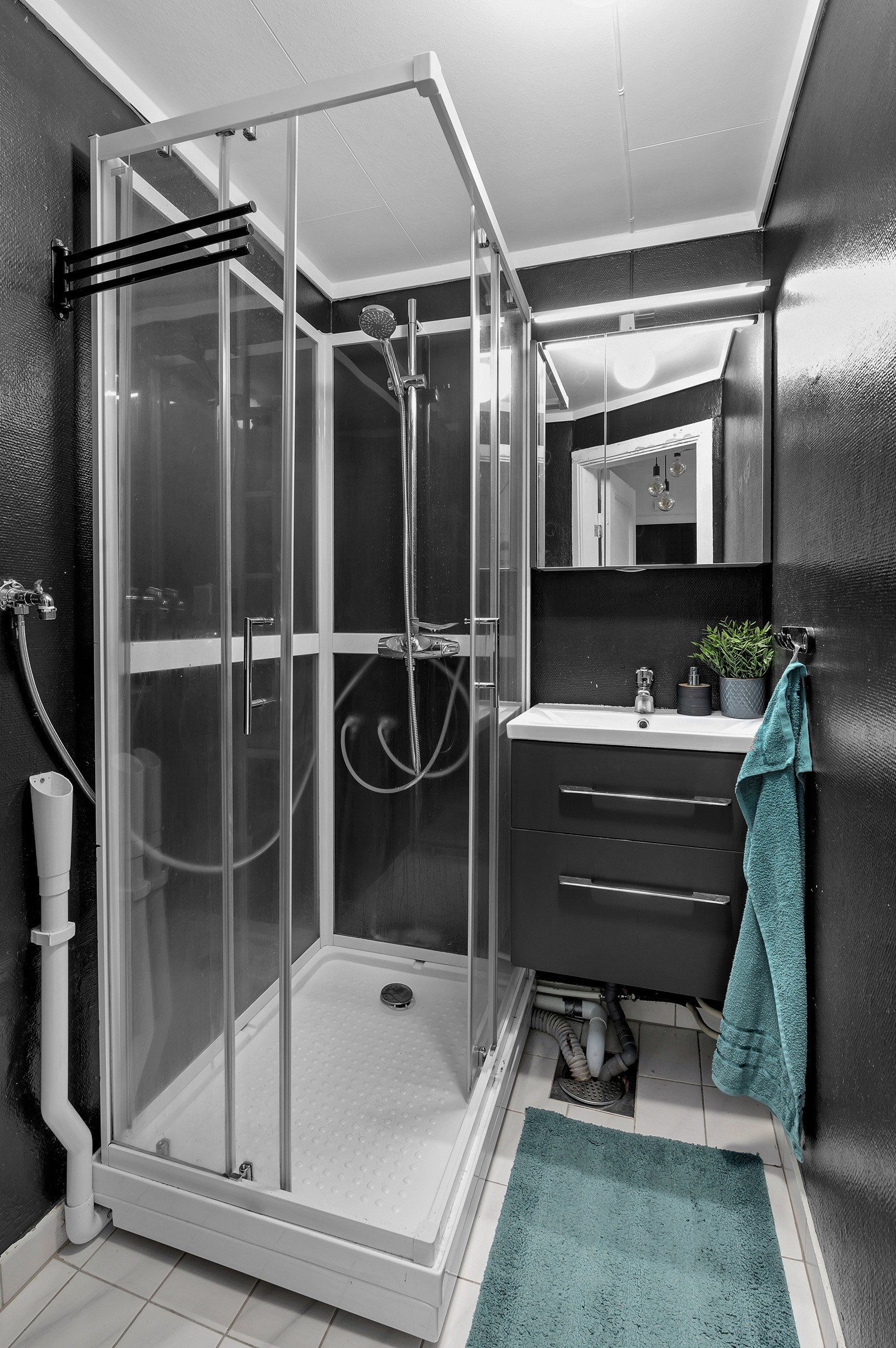 Flott bad med servant med speil og underskap, dusjkabinett og opplegg til vaskemaskin. Galleribilde