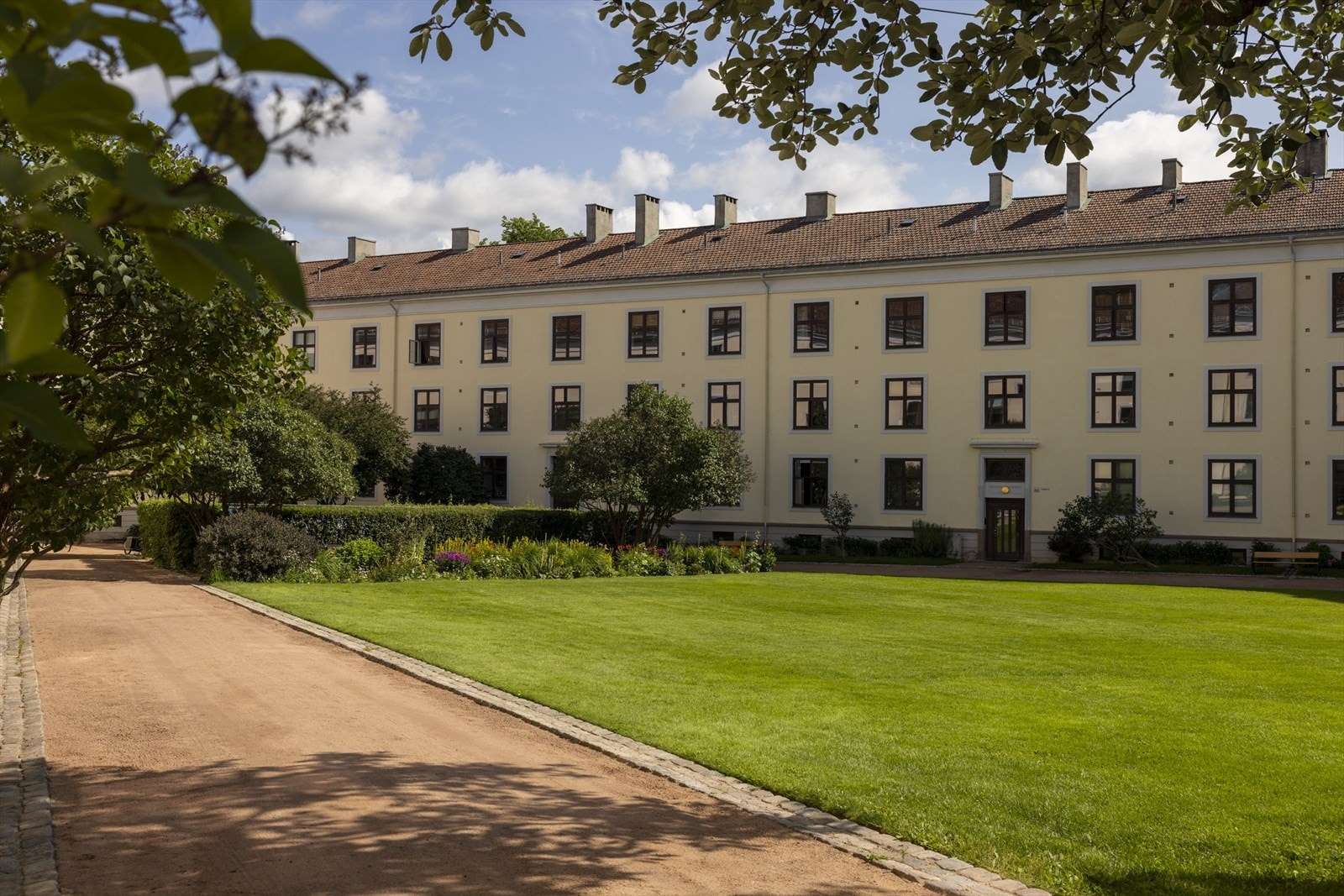 Beboere i borettslaget kan nyte godt av stor gressplen, grillplasser og flere sittegrupper for hyggelige sammenkomster Galleribilde