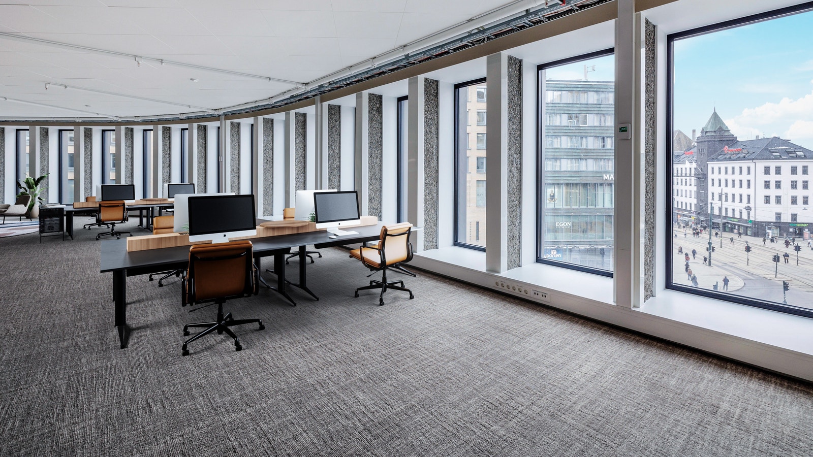 Her sitter du med god utsikt over Jernbanetorget og Oslo sentrum! Bildet er møblert ved hjelp av KI for å vise mulighetsrommet ved møblering av valg av arbeidsplasskonsept Galleribilde