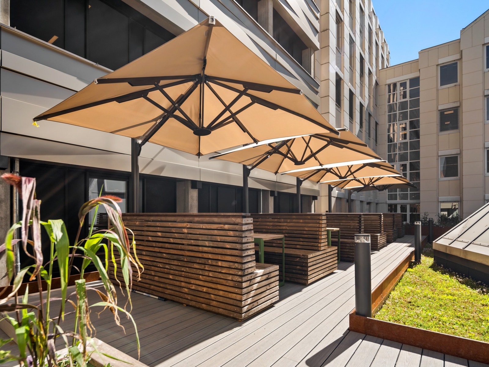 Ny takterrasse med flotte møbler, parasoller og blomsterbed, alt tilrettelagt for nydelig lunsj ute Galleribilde