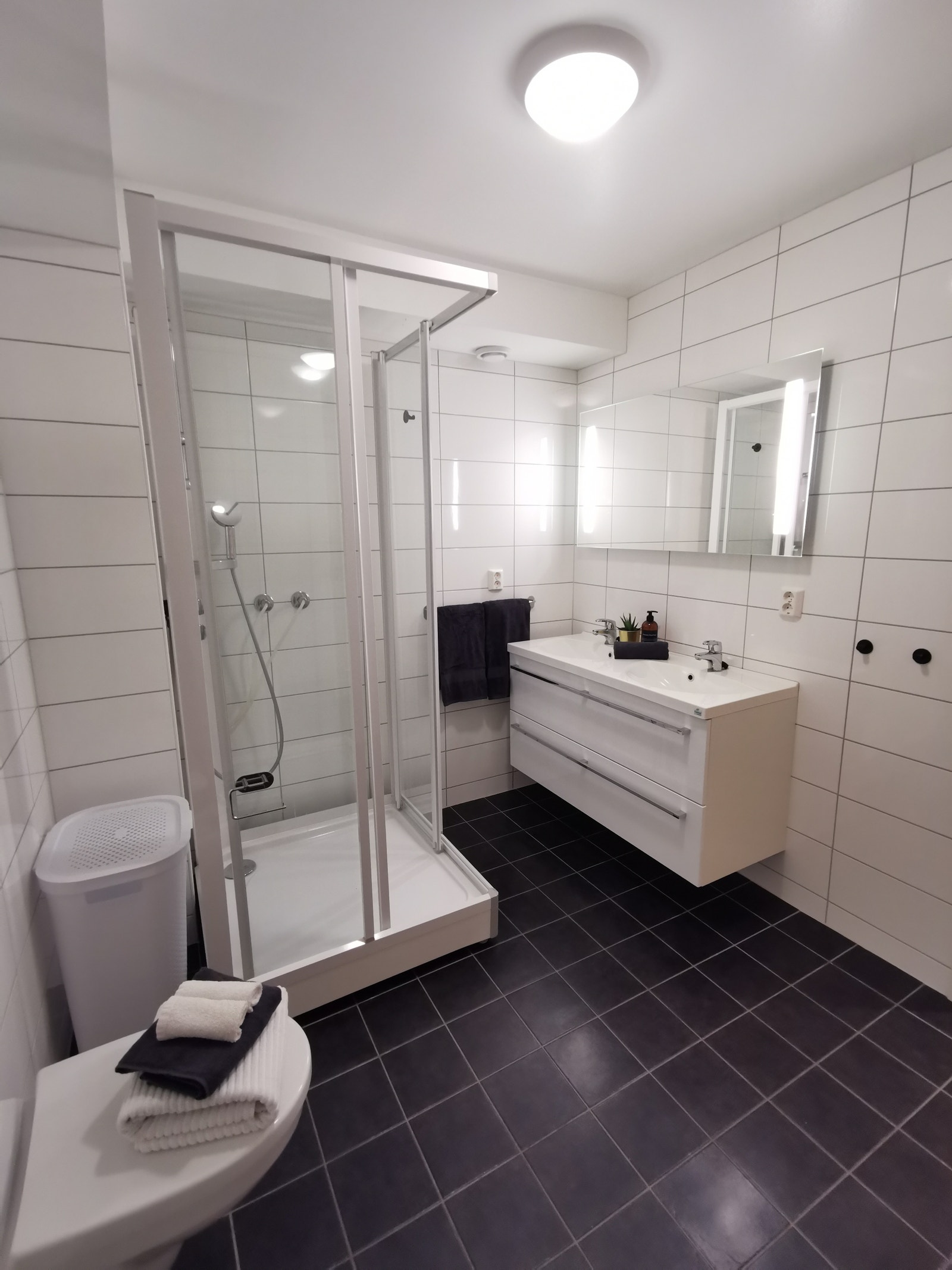 Stort, moderne bad. Fliser på både vegger og gulv. Galleribilde