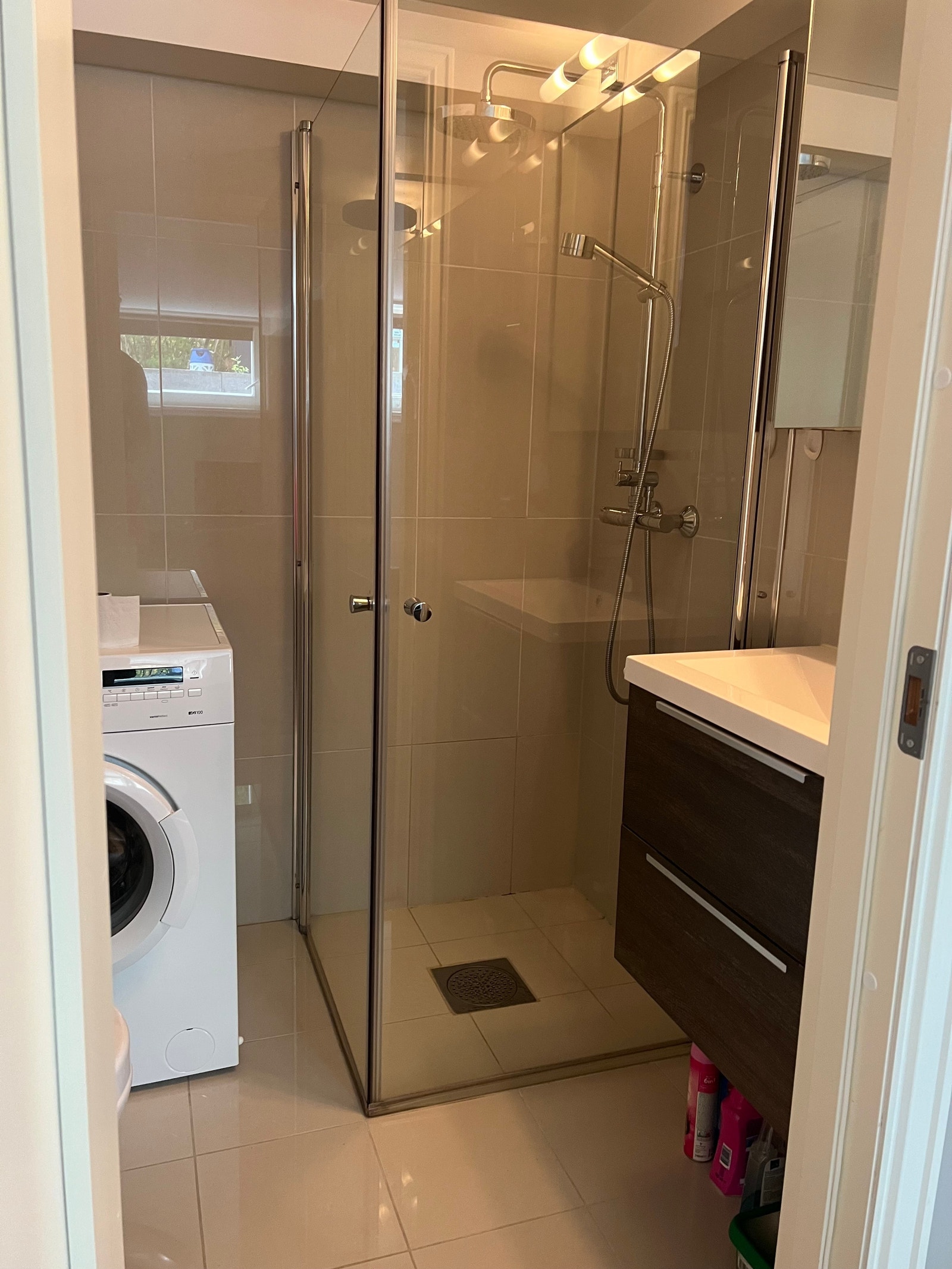 Bad med vegghengt wc, vaskemaskin, dusjhjørne og servant. Galleribilde